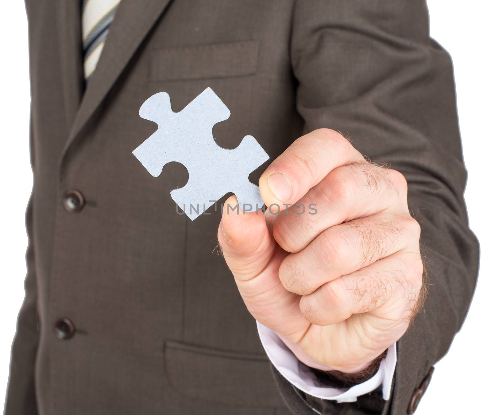 Close up of businessman hand holding puzzle piece isolated on white background