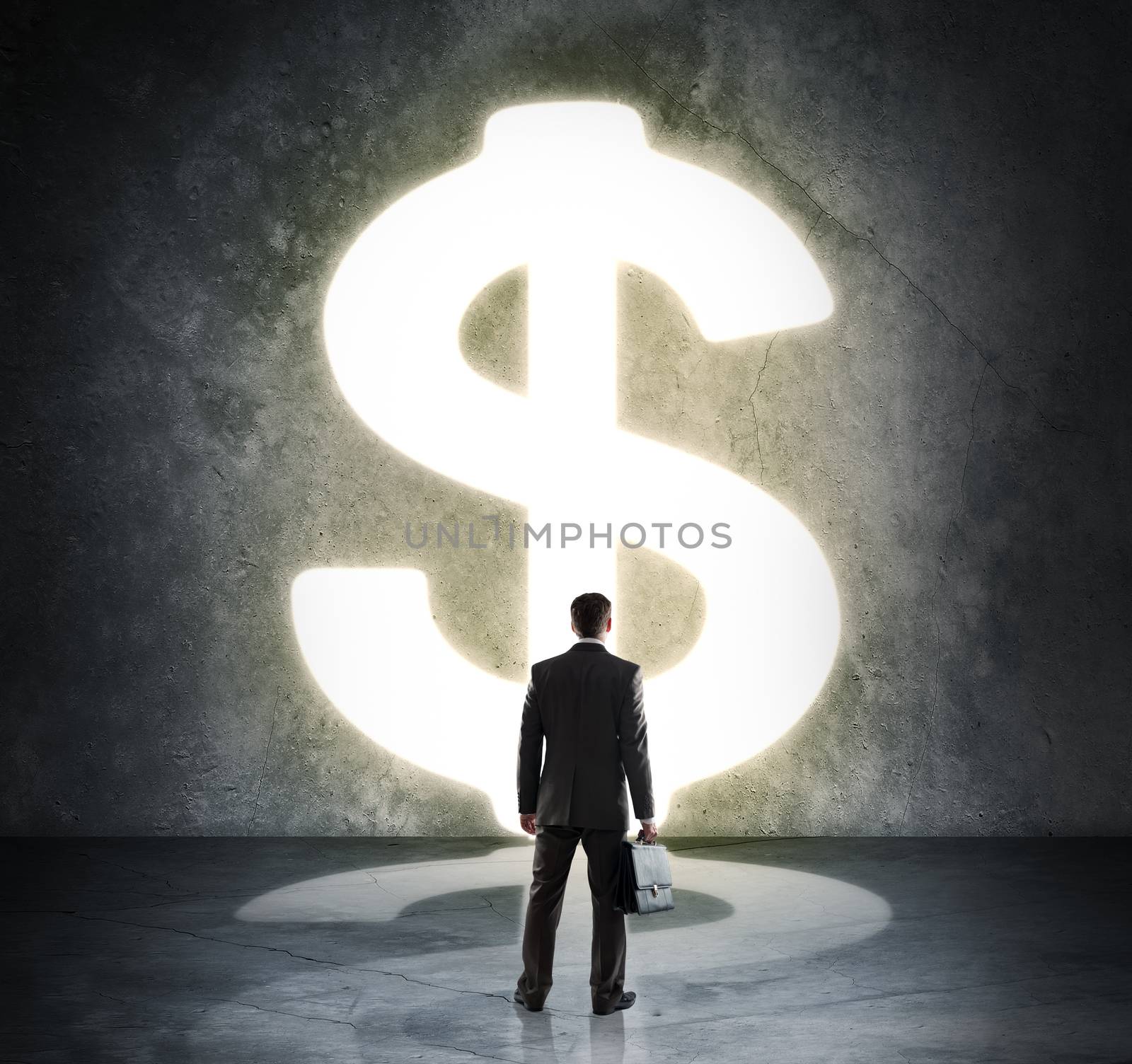 Businessman standing in light of dollar sign by cherezoff
