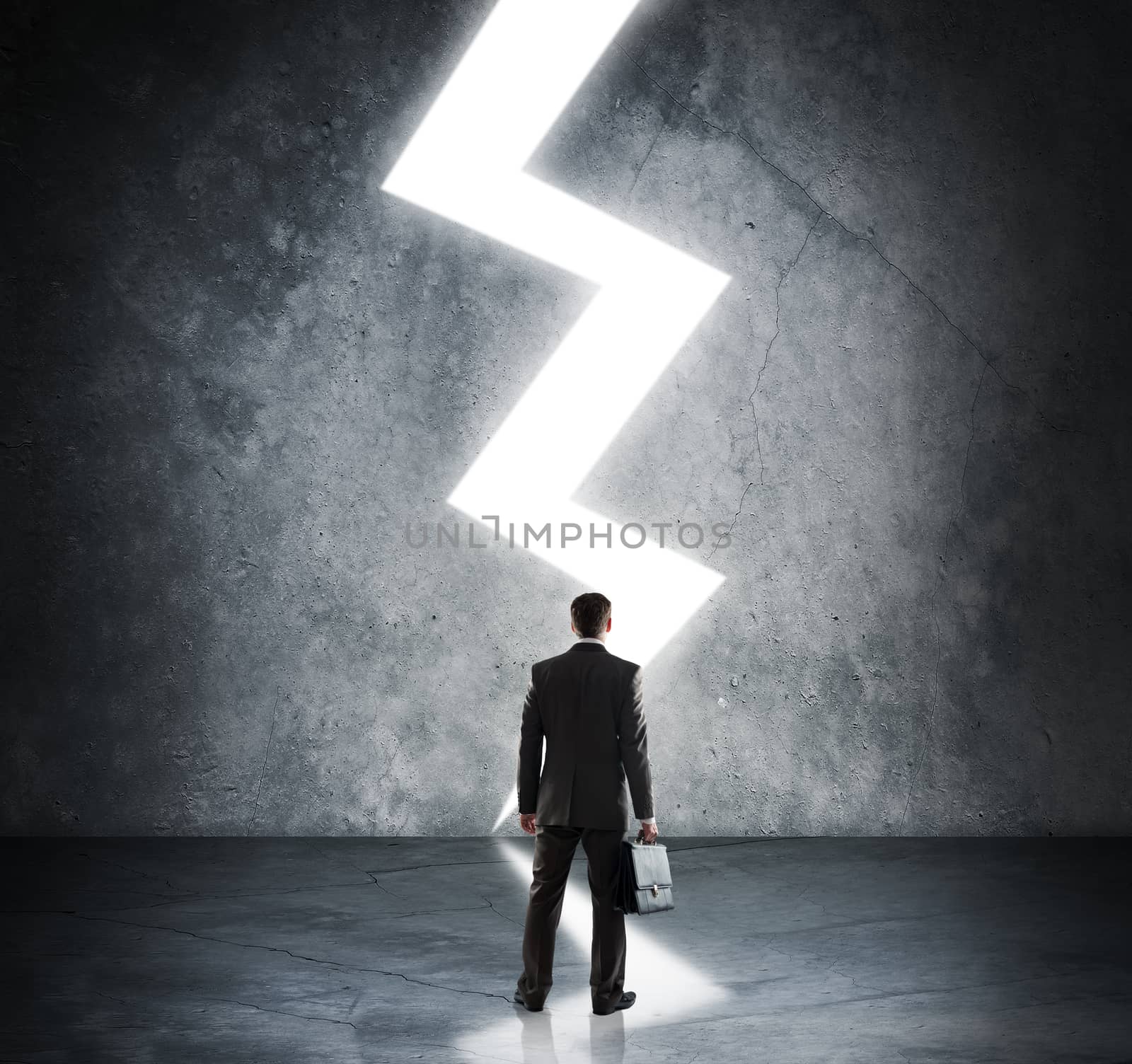 Businessman standing in light of lightning sign by cherezoff