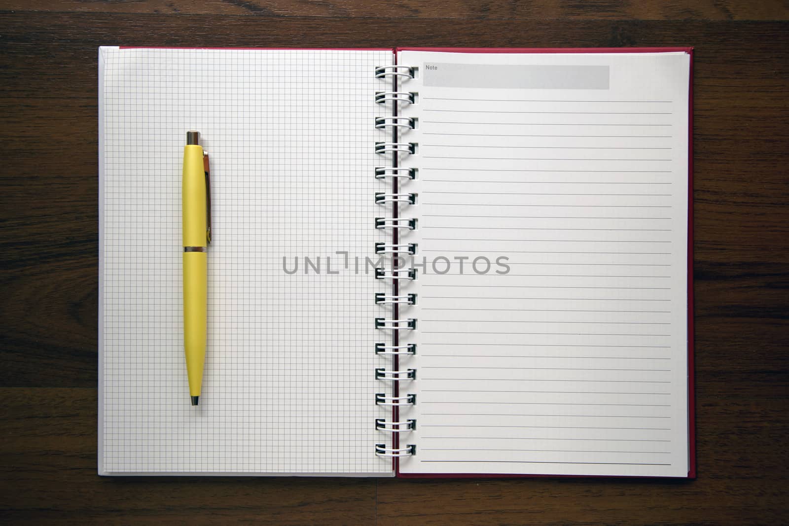 Blank notebook paper on wooden desk background