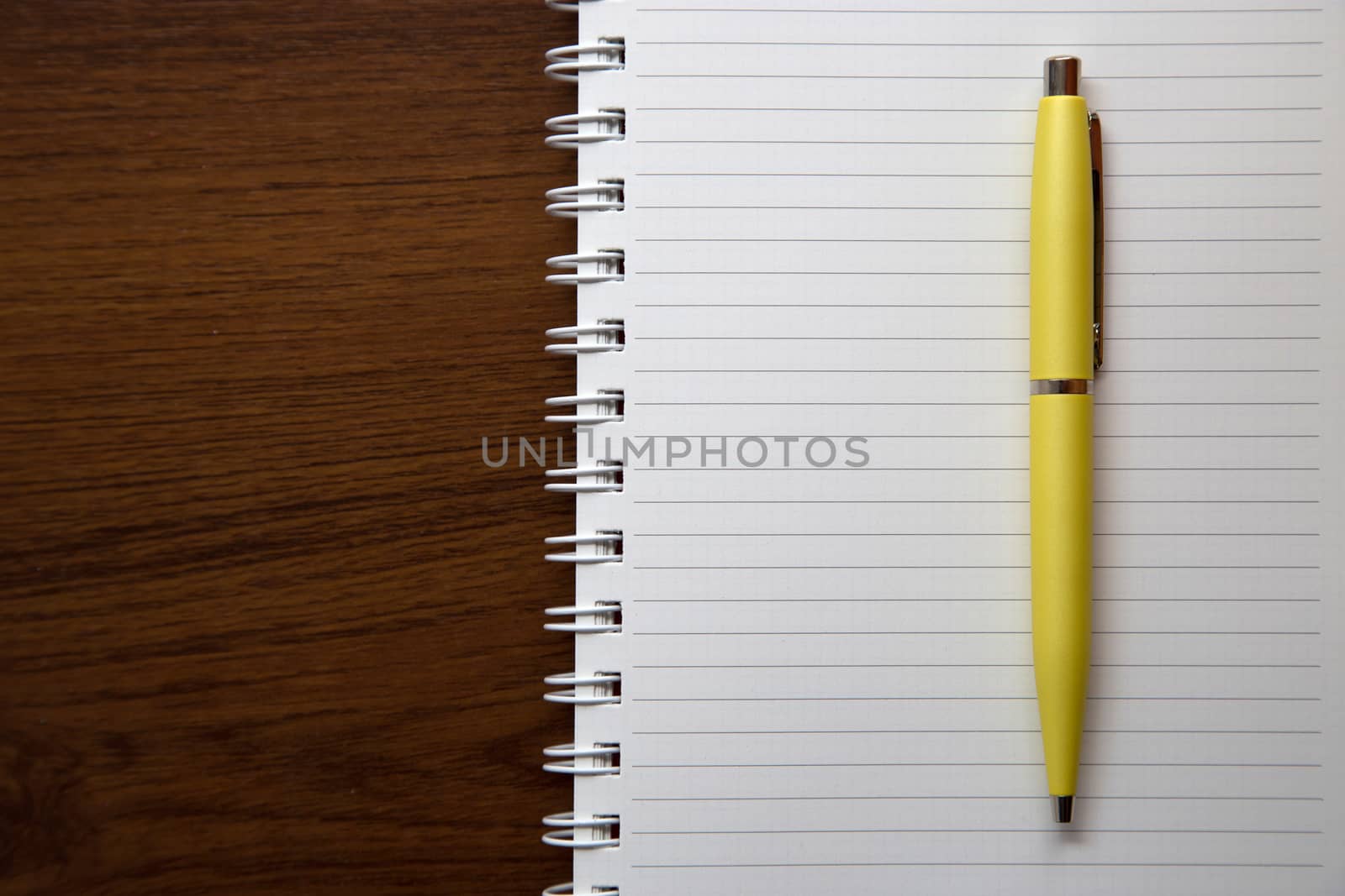 Blank notebook paper on wooden desk background