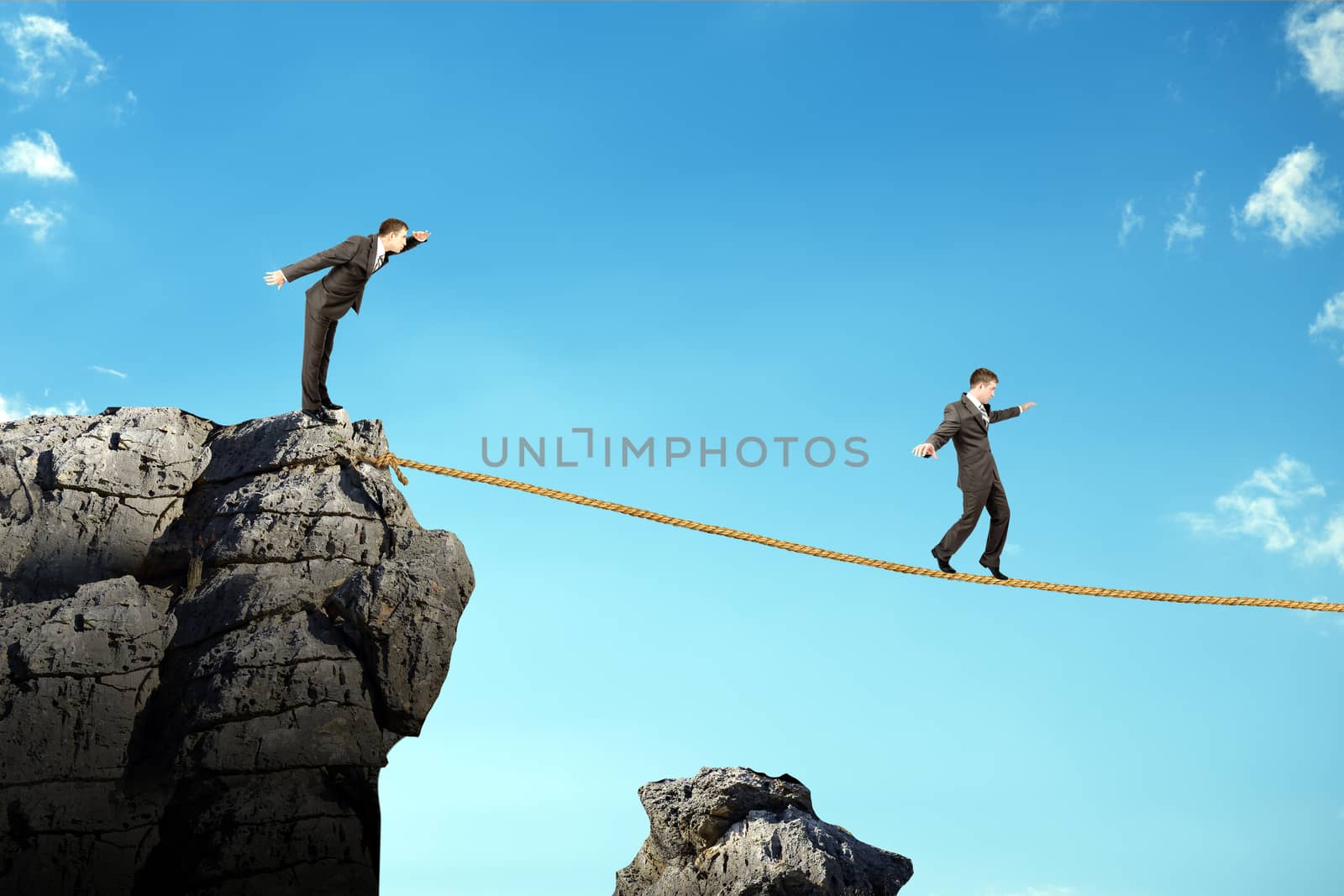 Businessman walking on rope above gap by cherezoff