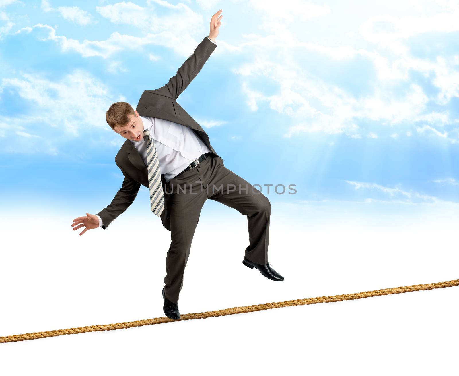 Young businessman try to walk on rope by cherezoff