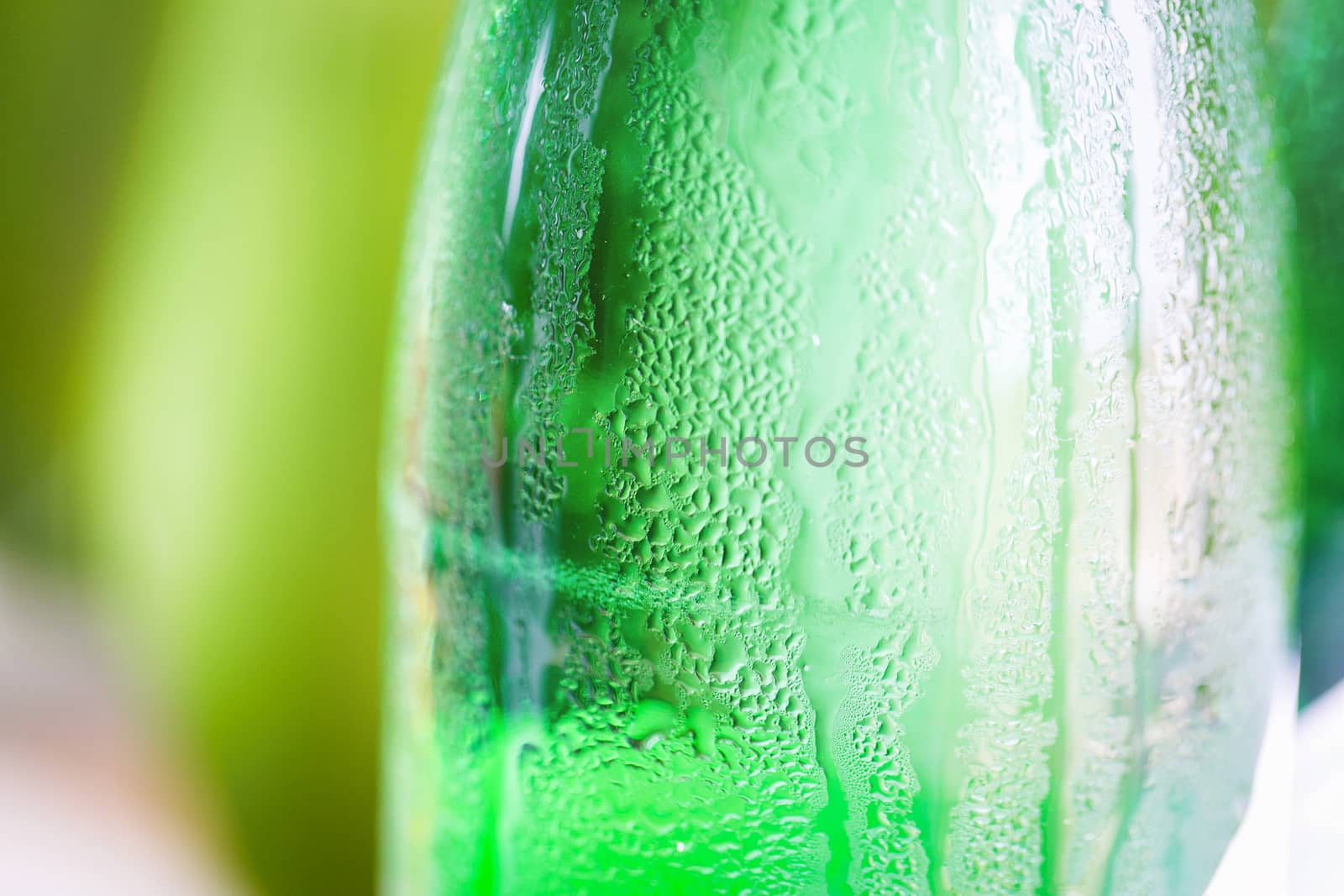 Green glass bottle with condensation on it