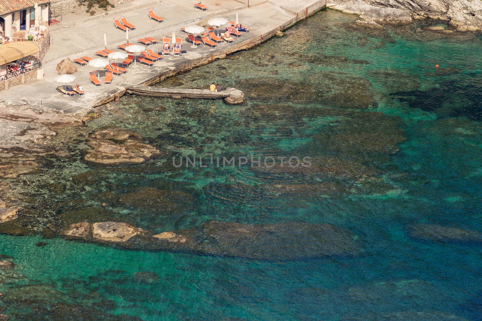 Aeral view of sicilian beach with people, umbrellas and wonderful sea.