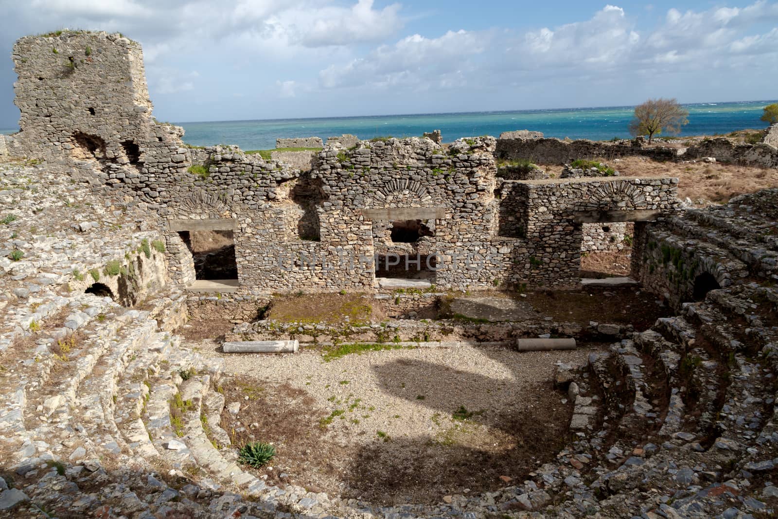 View of historical old amphitheater in Anemurium ancient city in Mersin, on cloudy blue sky background.