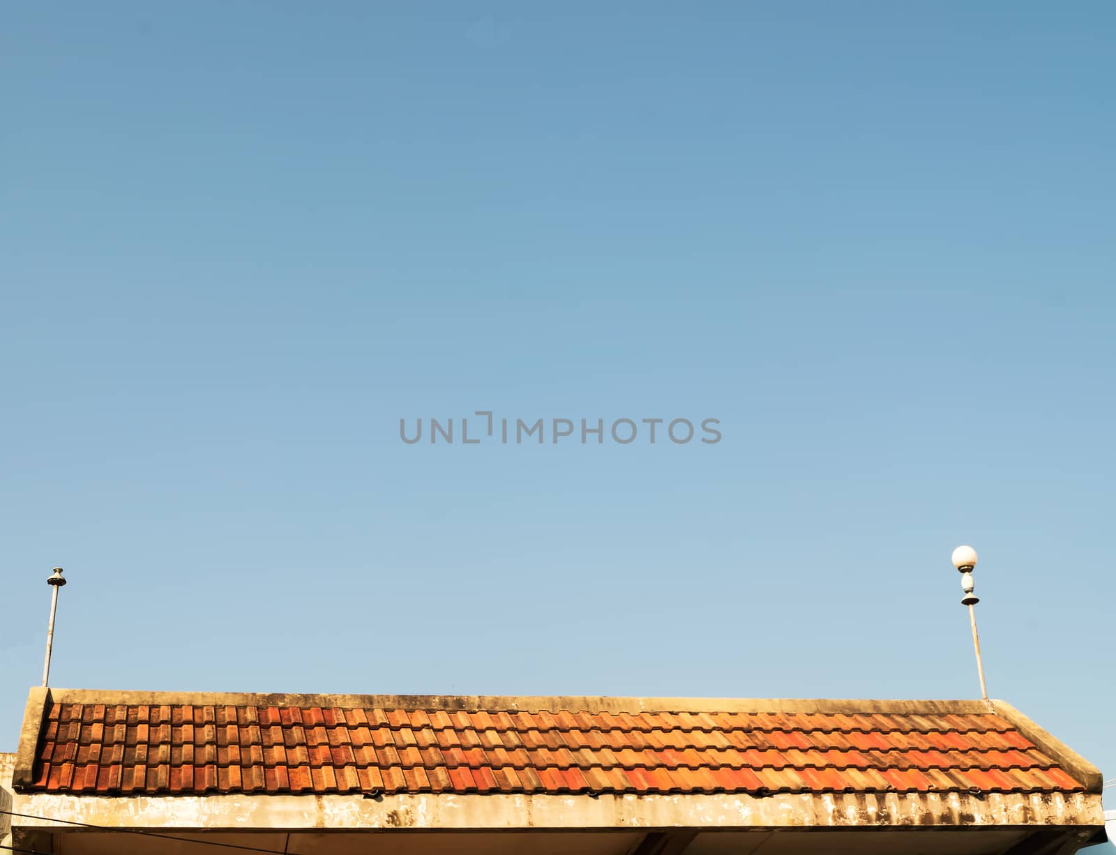 Old roof house with orange tile roof on blue sky by suthee