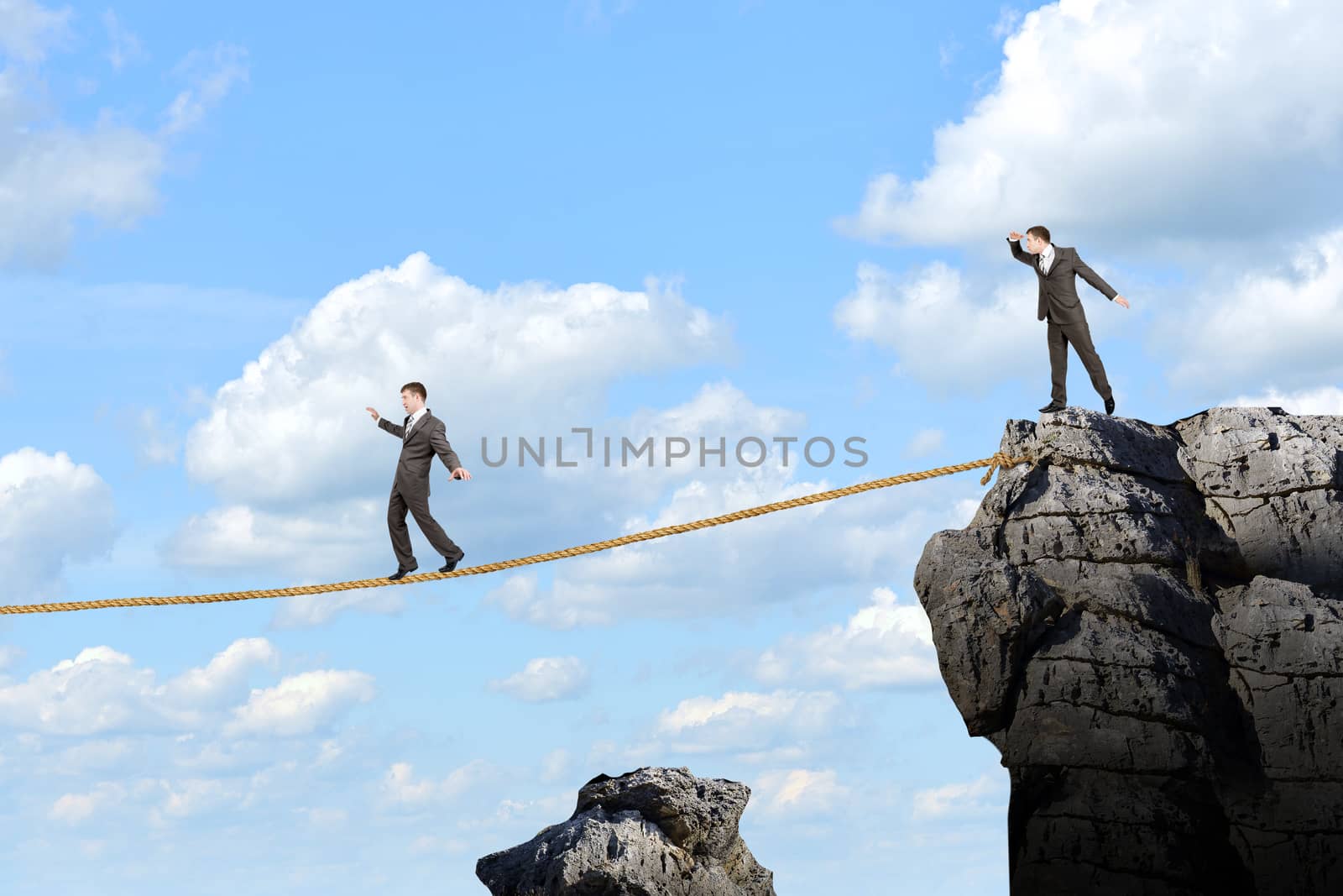 Image of businessman walking on rope above gap