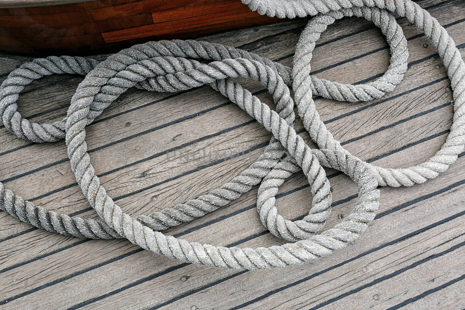 Coiled rope on a wooden deck by gorov108