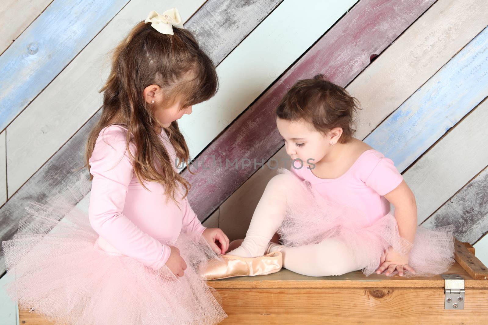 Friends playing dress-up in ballet costumes against colorful background