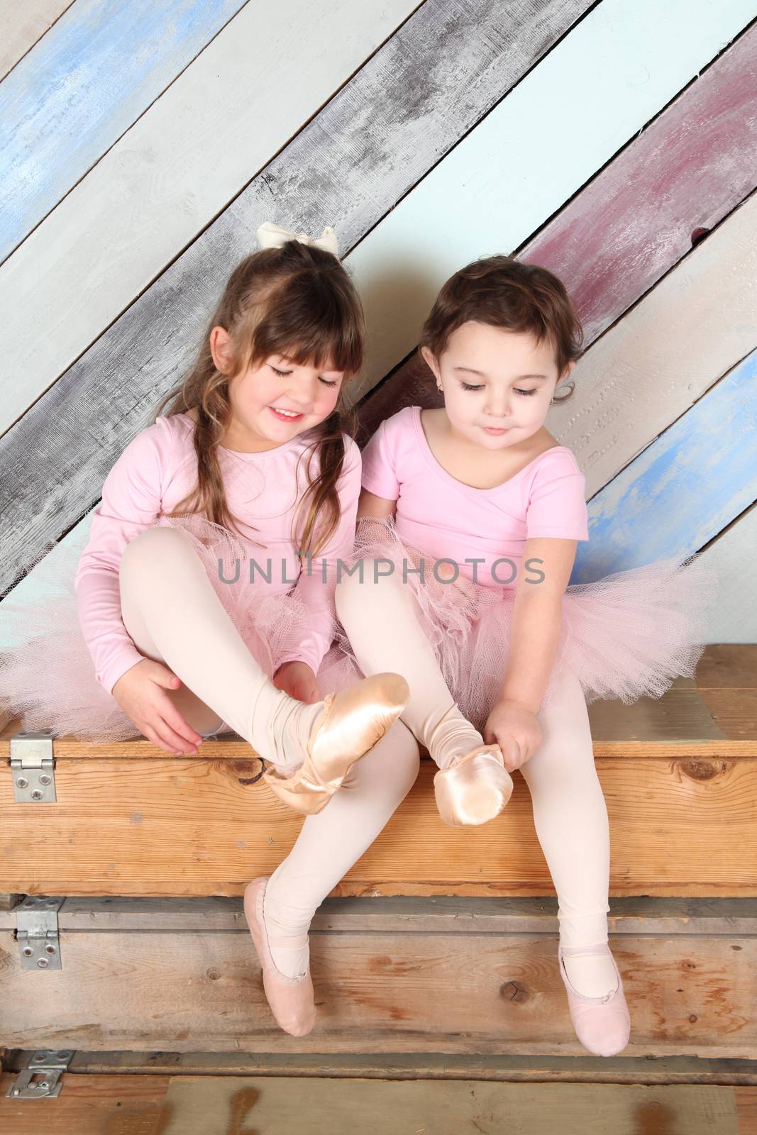 Friends playing dress-up in ballet costumes against colorful background