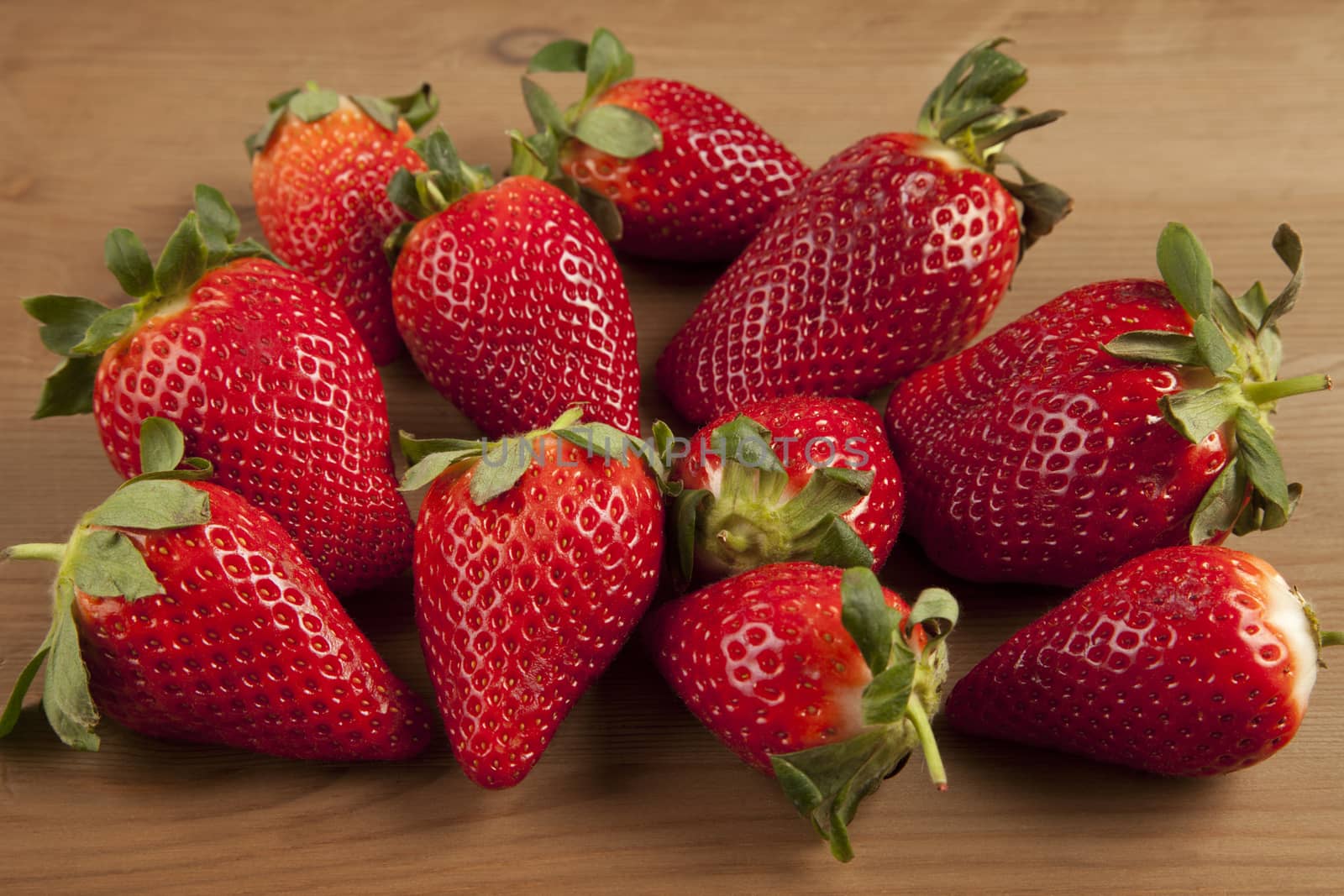 Ripe strawberries over wooden table background 