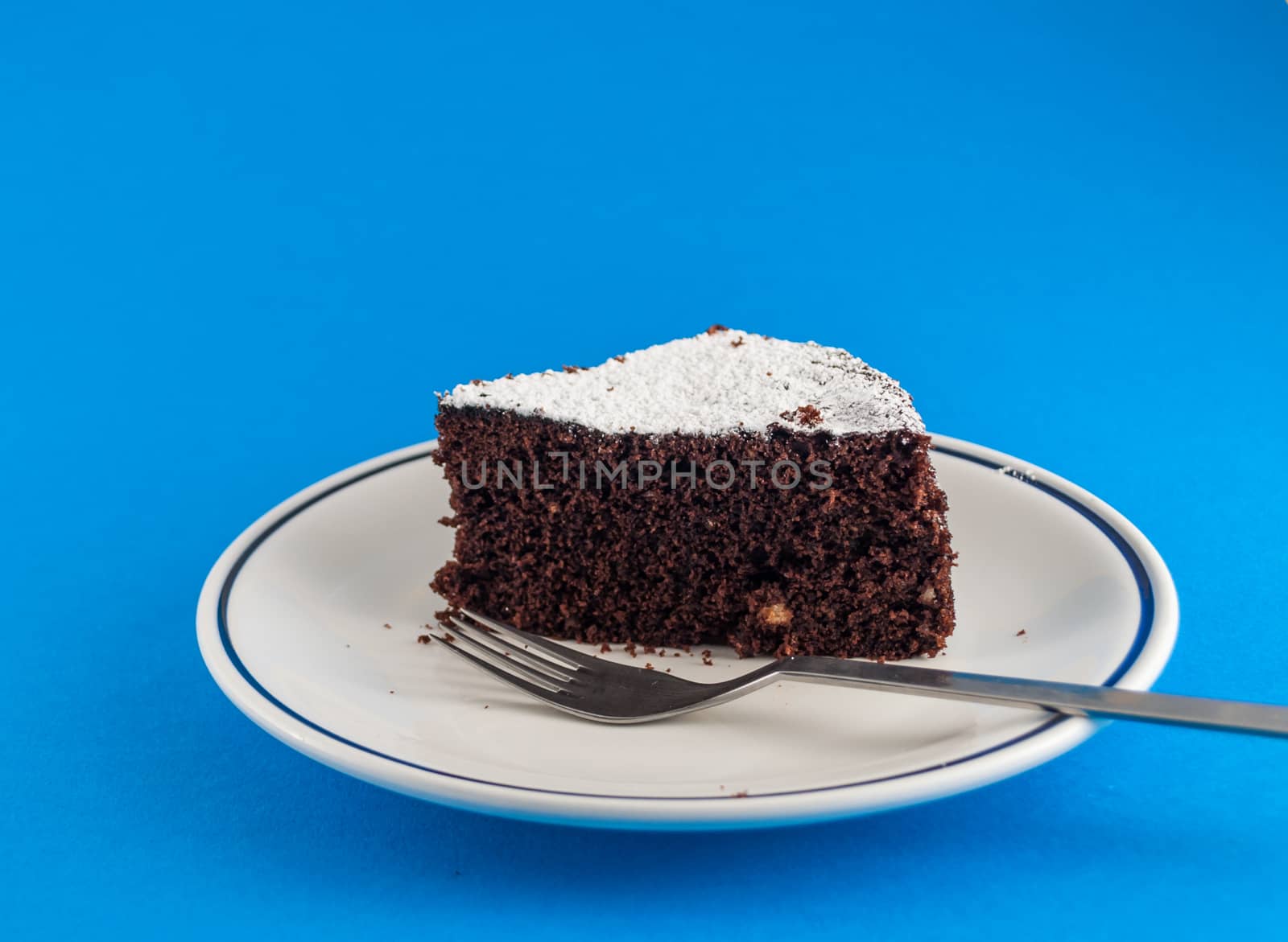 CLoseup of slice of chocolate cake  on colored background