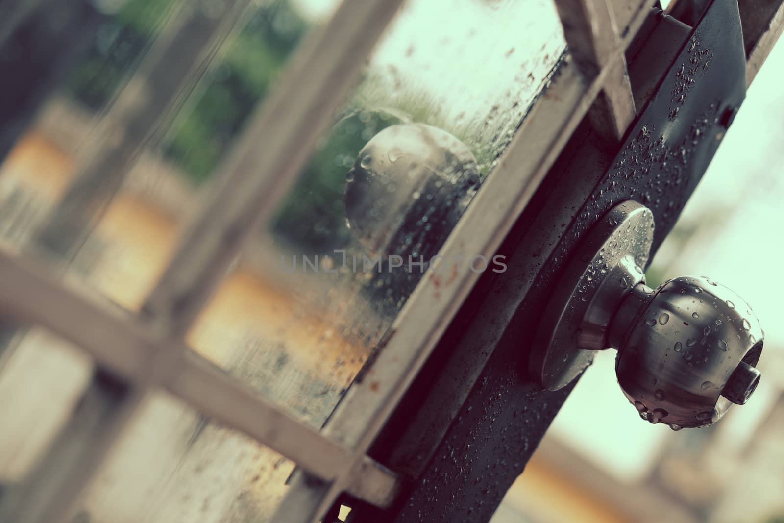 Rain drops on door handle and glass window in rainy day, drop of water falling make lonely feeling of cold day