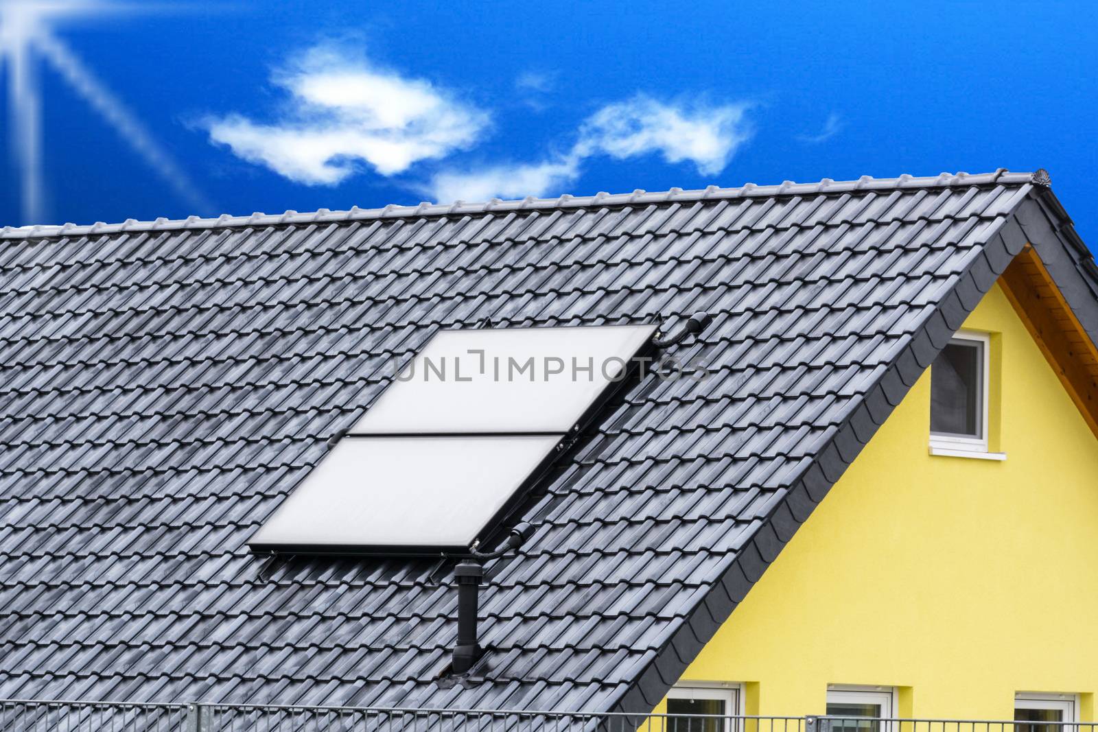 Solar panels on the roof of a house with blue sky in the background.
