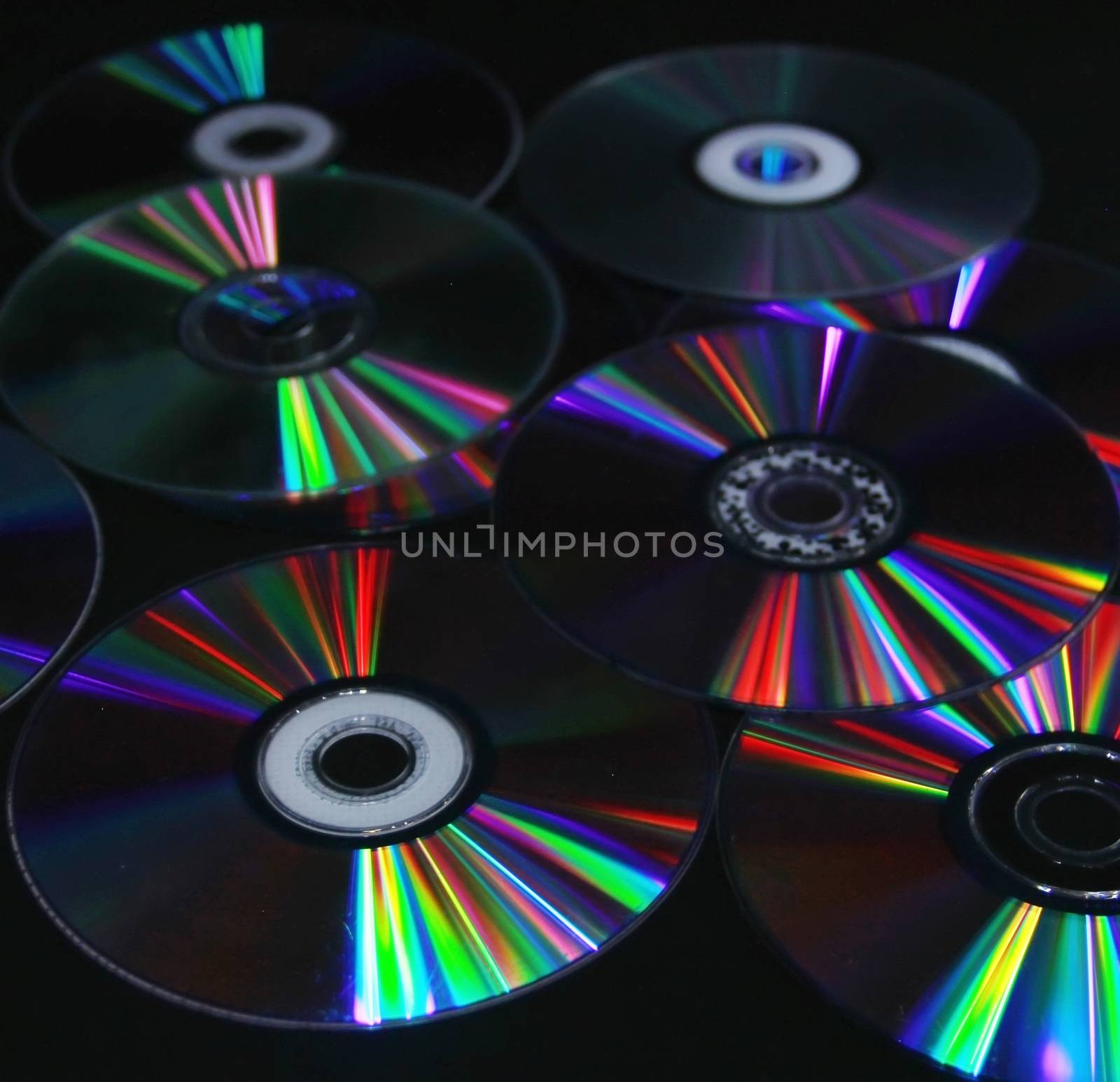 CDs DVD on a black background modern technologies the color spec by KoliadzynskaIryna