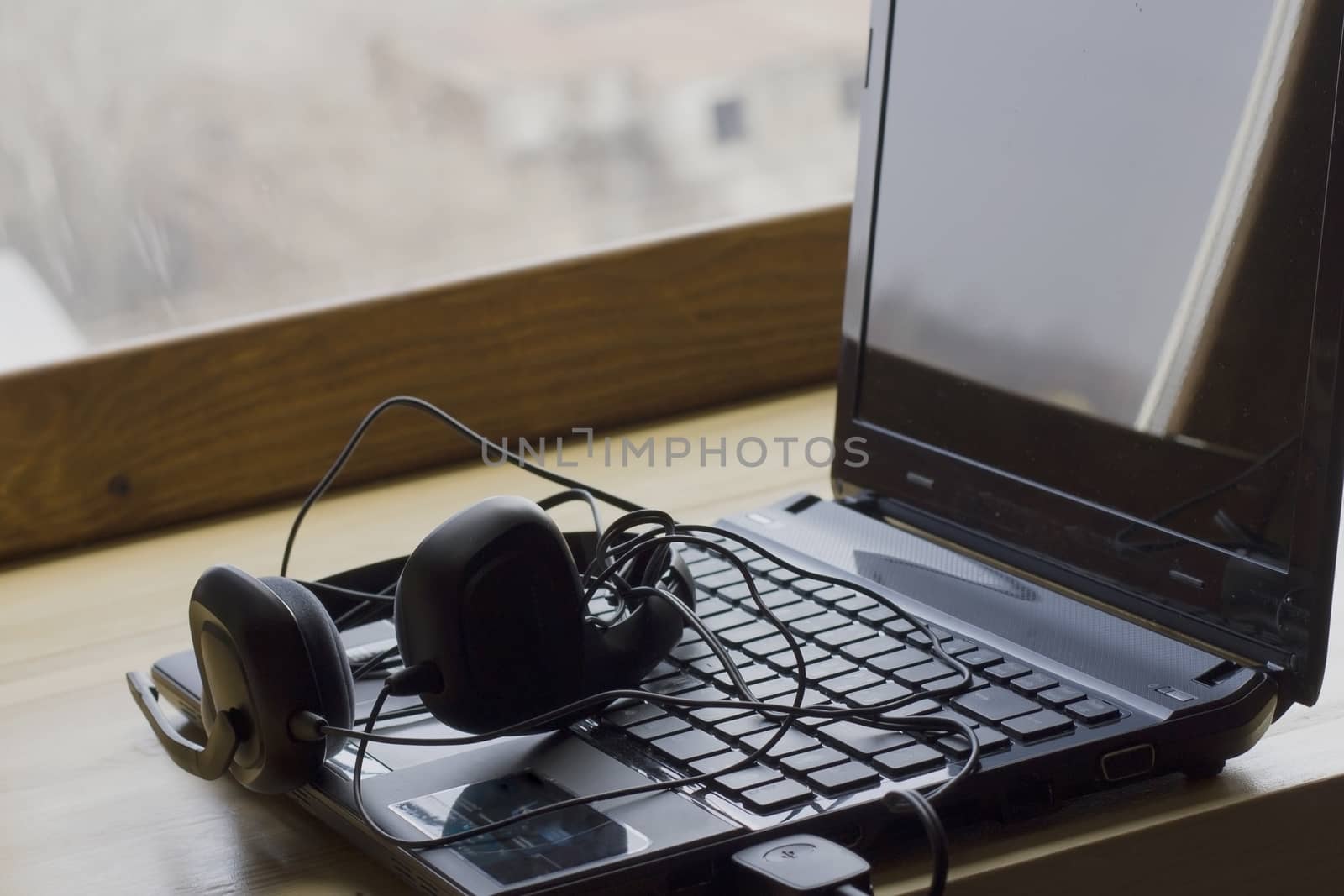 laptop and headphones lie at the window listening to music on a  by KoliadzynskaIryna