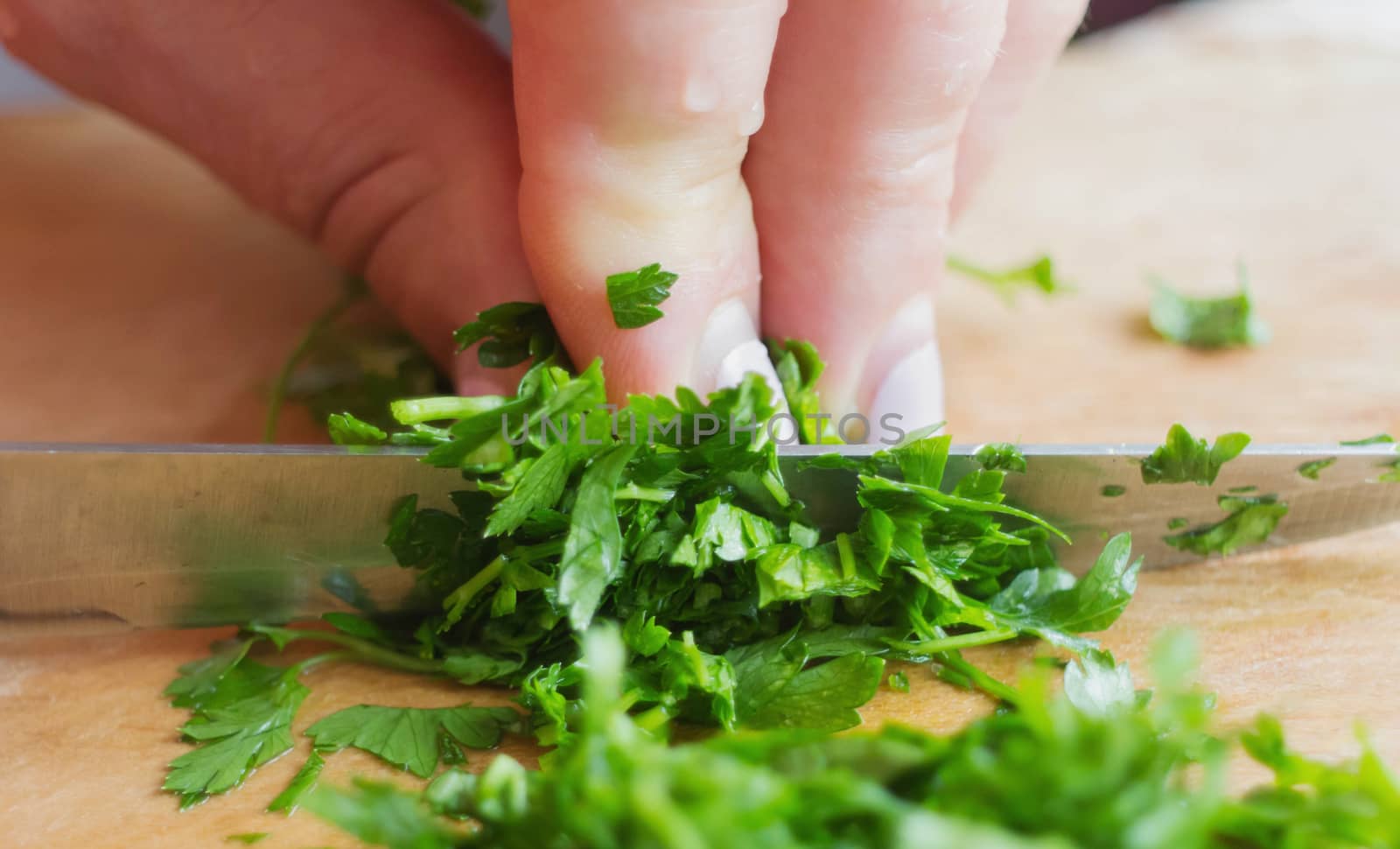 Hand sliced green chopped parsley on the table Kitchen interior by KoliadzynskaIryna