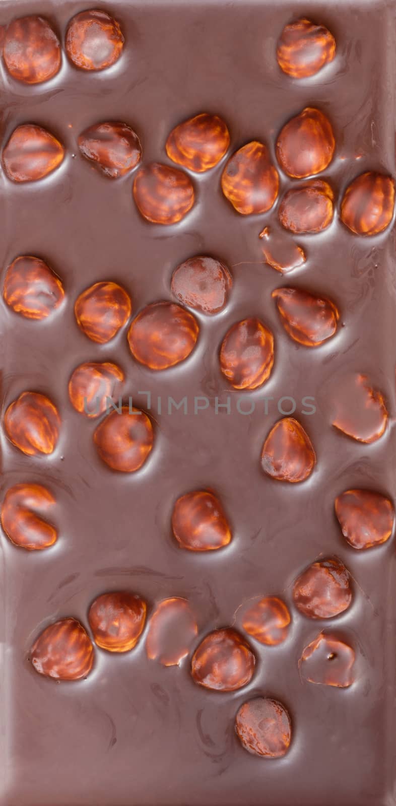 background of milk chocolate with hazelnuts close-up