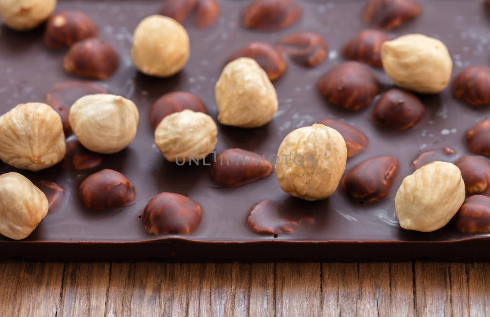 milk chocolate with hazelnuts on a wooden background