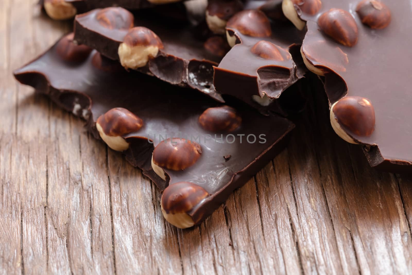 milk chocolate with hazelnuts on a wooden background