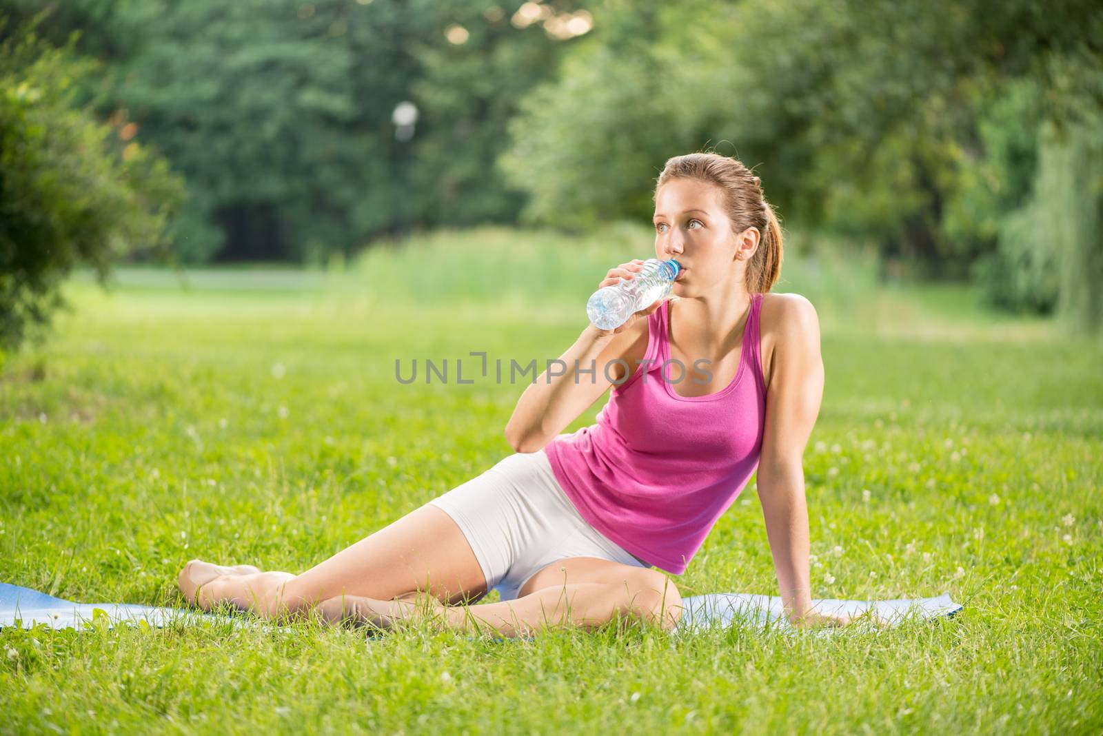 Beautiful young woman resting after exercising in the park.