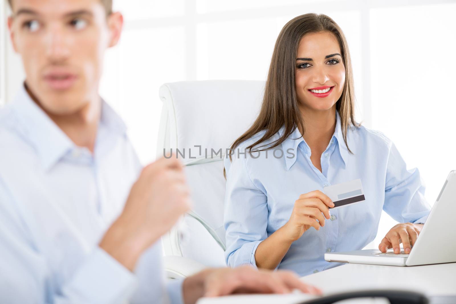 Young beautiful businesswomanholding credit card in the office