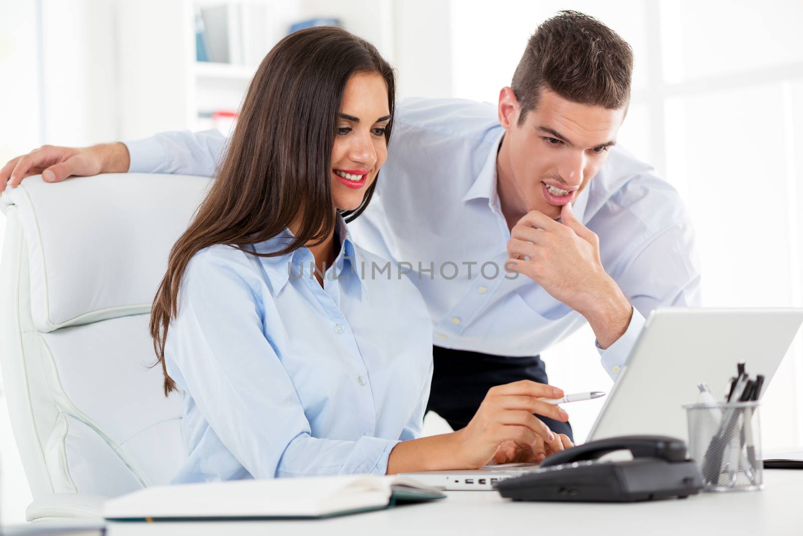 Young beautiful businesswoman and businessman discussing and working in the office