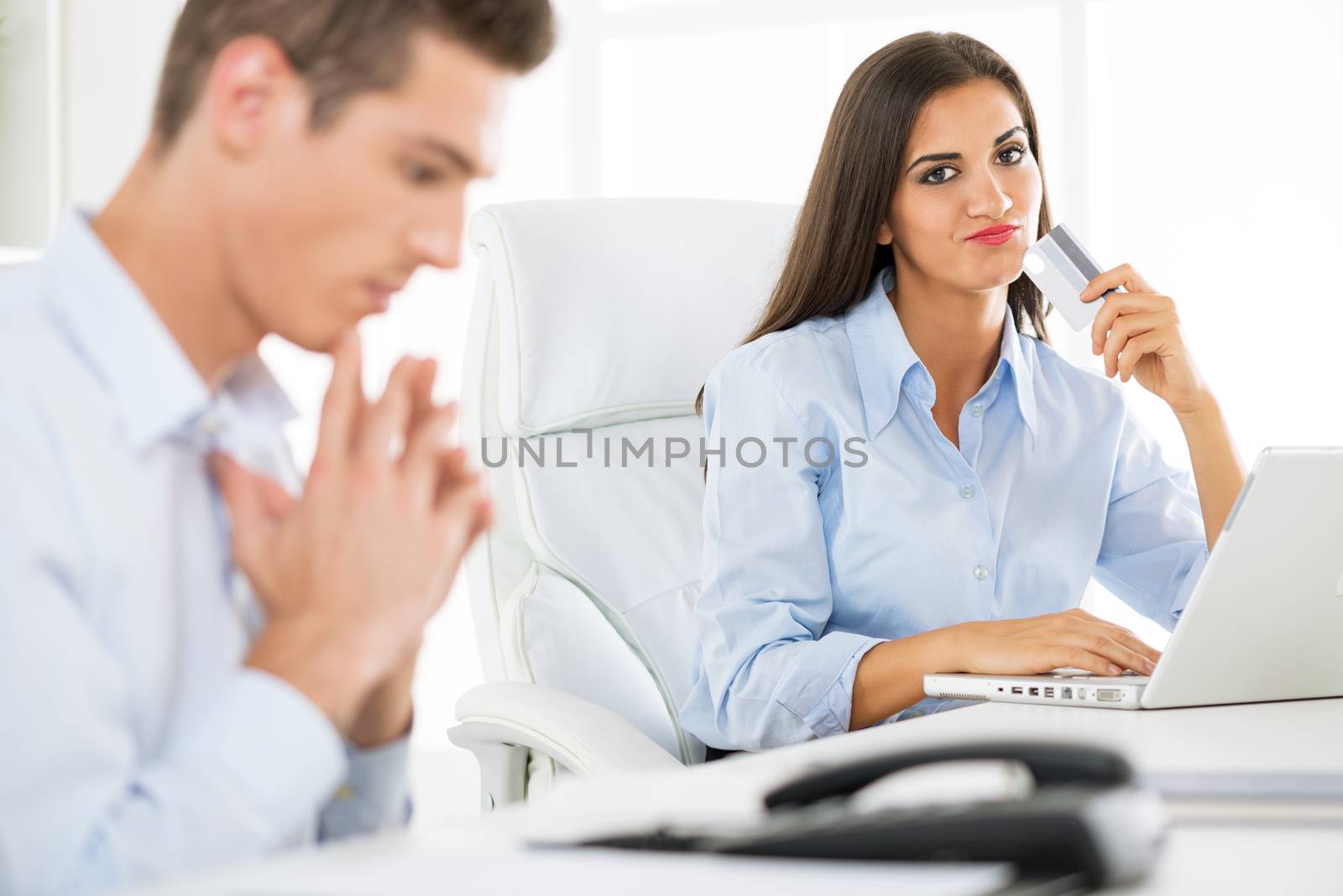 Young beautiful businesswomanholding credit card in the office