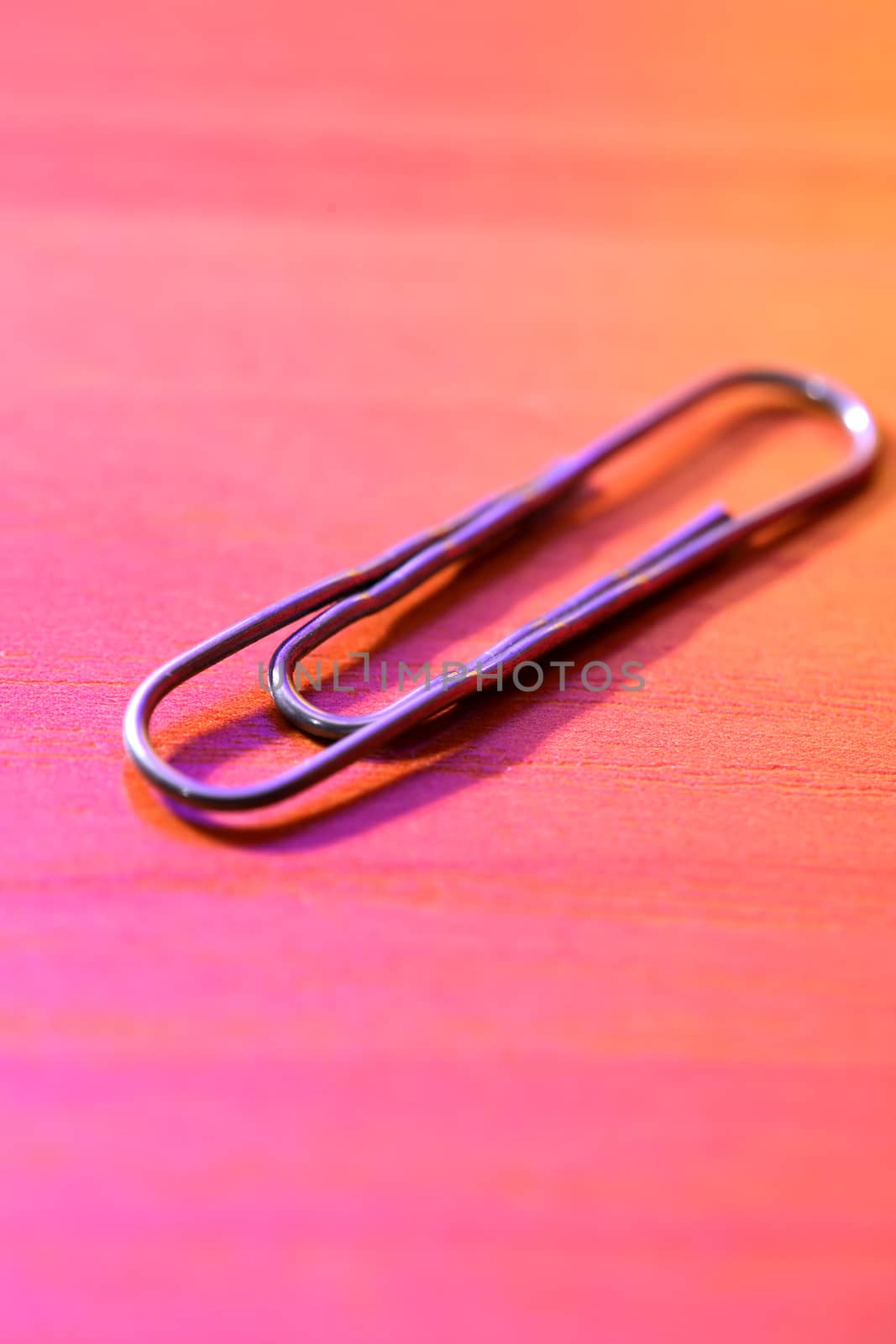 Closeup of metal paper clip on colorful background