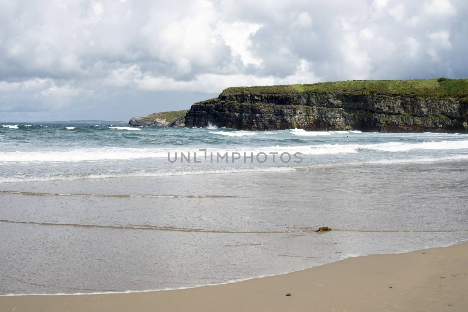 big waves rolling into the cliffs and beach in ballybunion on the wild atlantic way