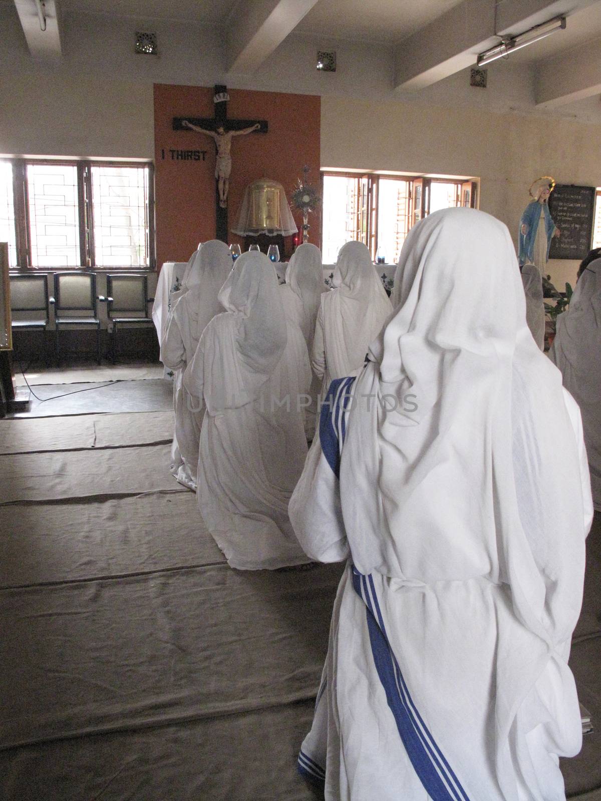 Sisters of Mother Teresa's Missionaries of Charity in prayer in the chapel of the Mother House, Kolkata by atlas