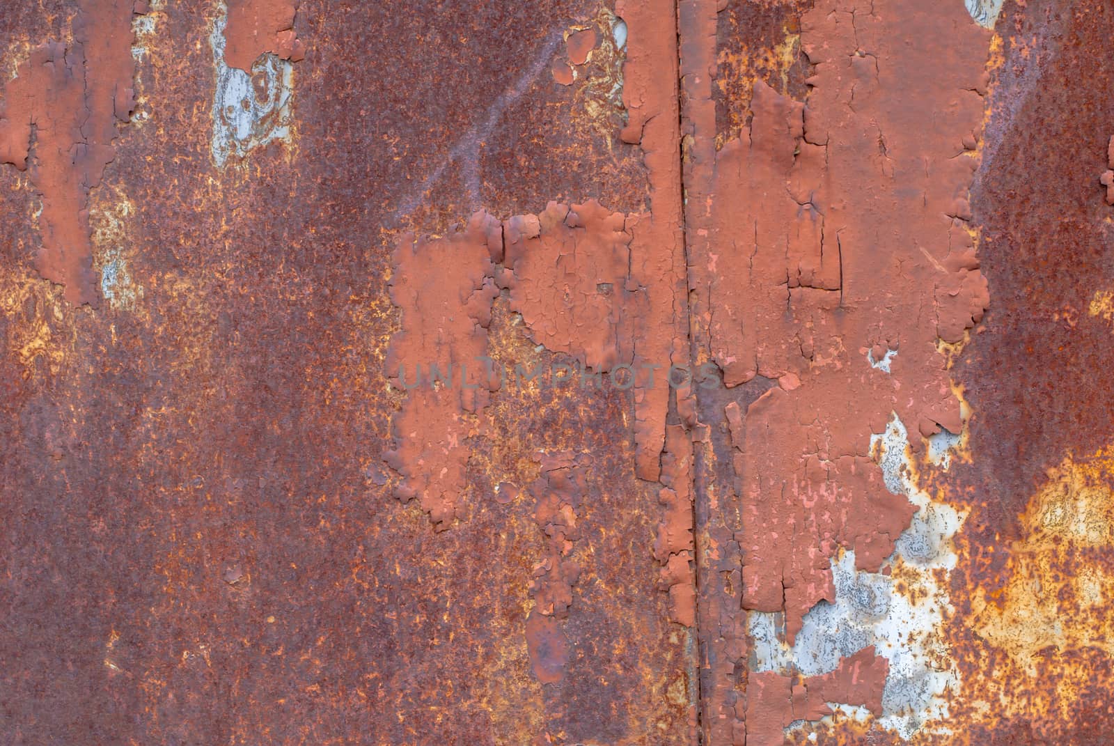 rusty iron surface covered with old chipped paint, which has long been influenced by different climatic conditions