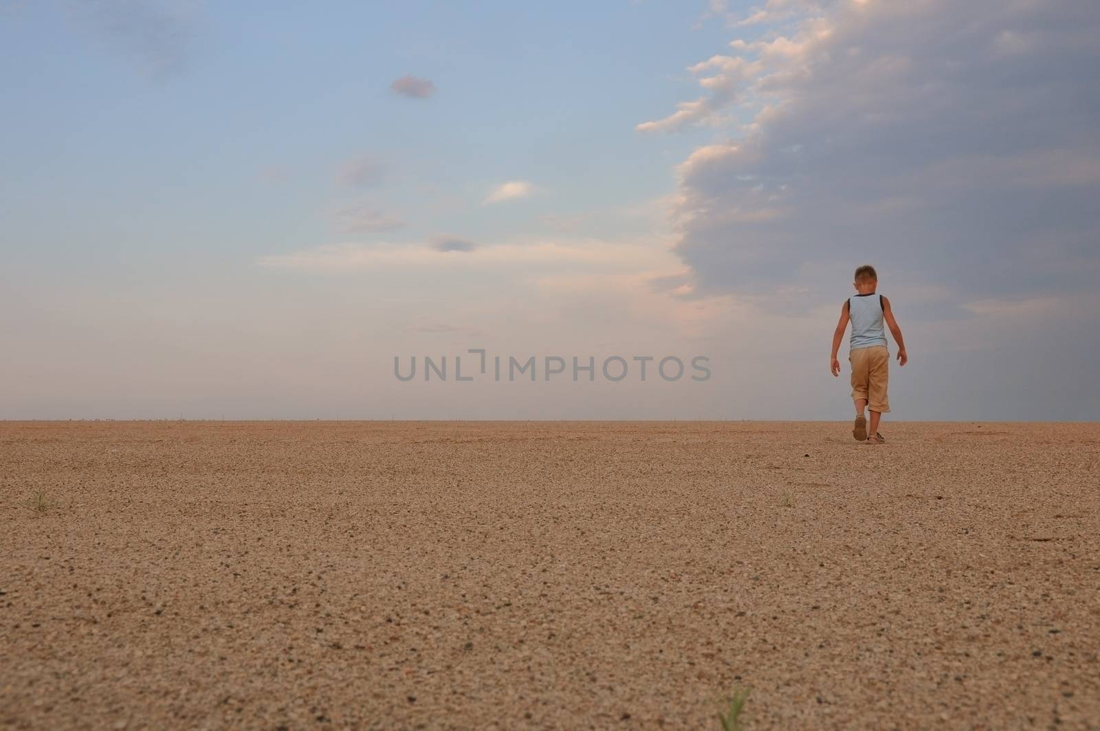 young man go up in sand desert in sundown