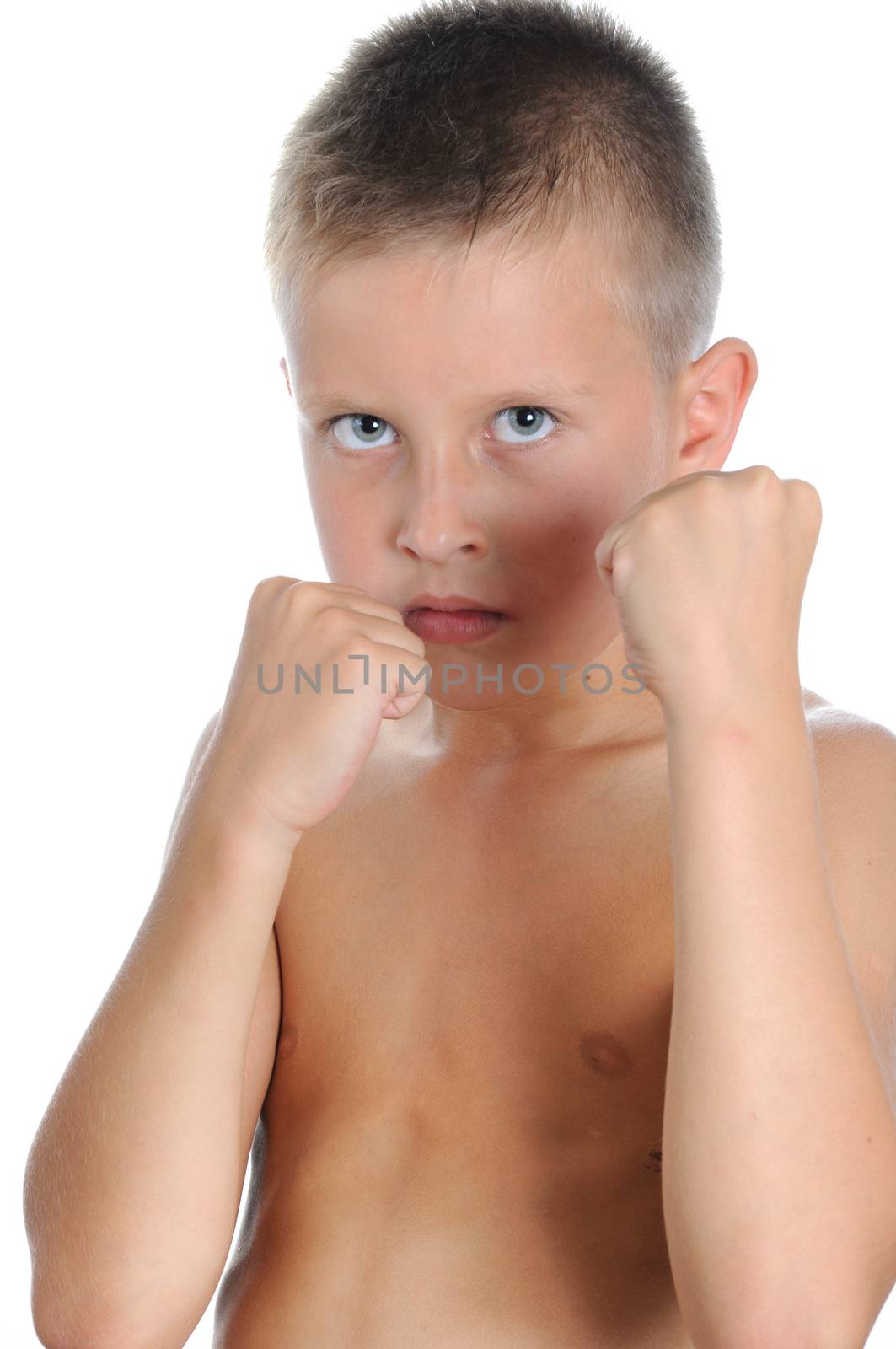 Serious and determined young boy wearing like boxing gloves and looking at the camera. Isolated on white