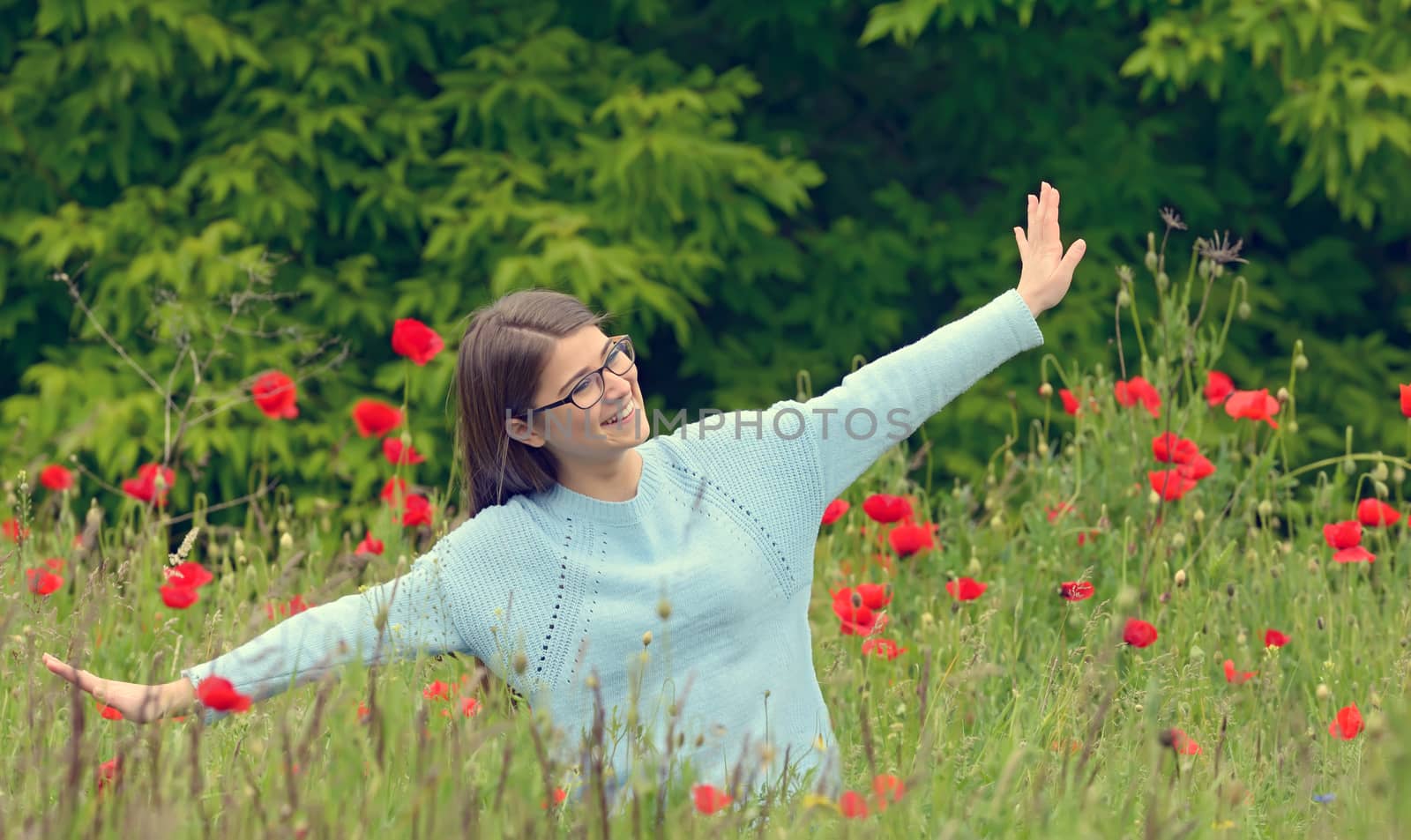 Young girl playing in a poppy field