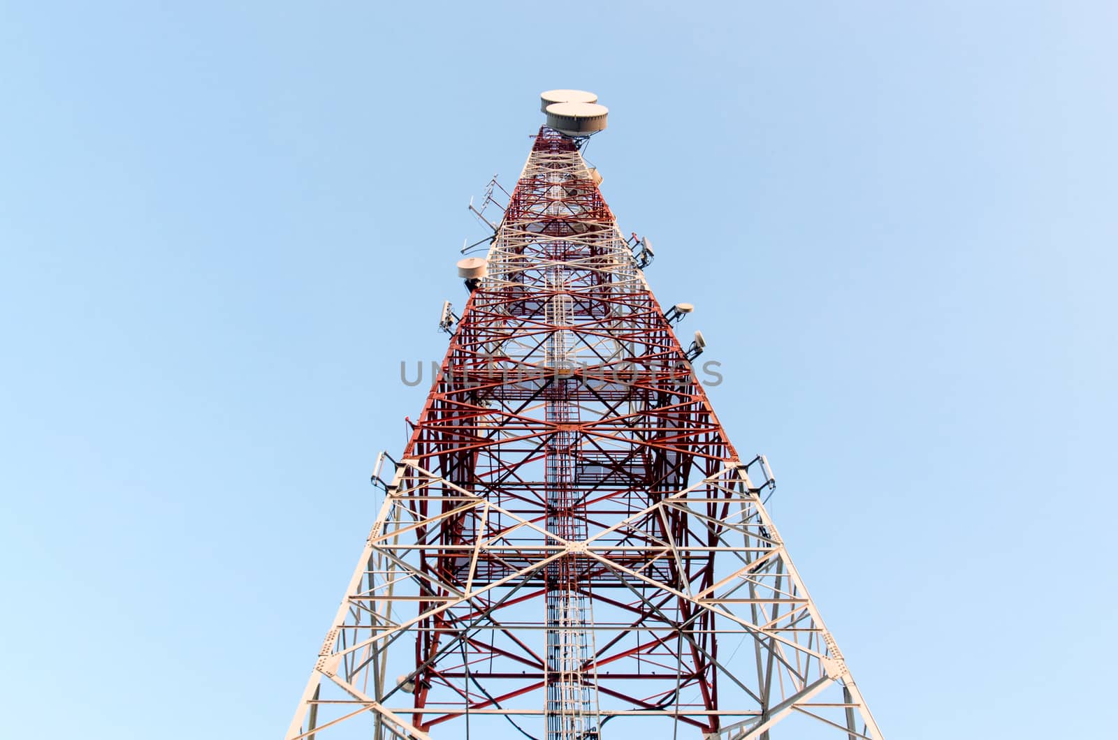 Telecommunications tower with clear blue sky.