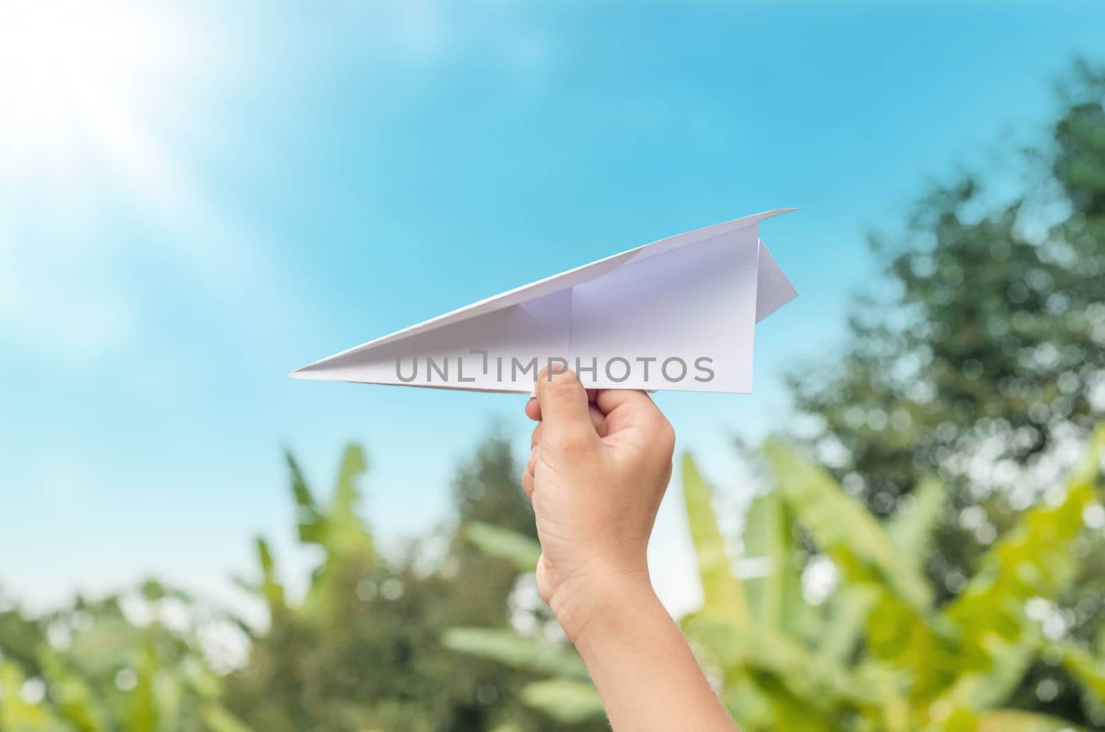 plane paper in children hand in farm and blue sky by koson