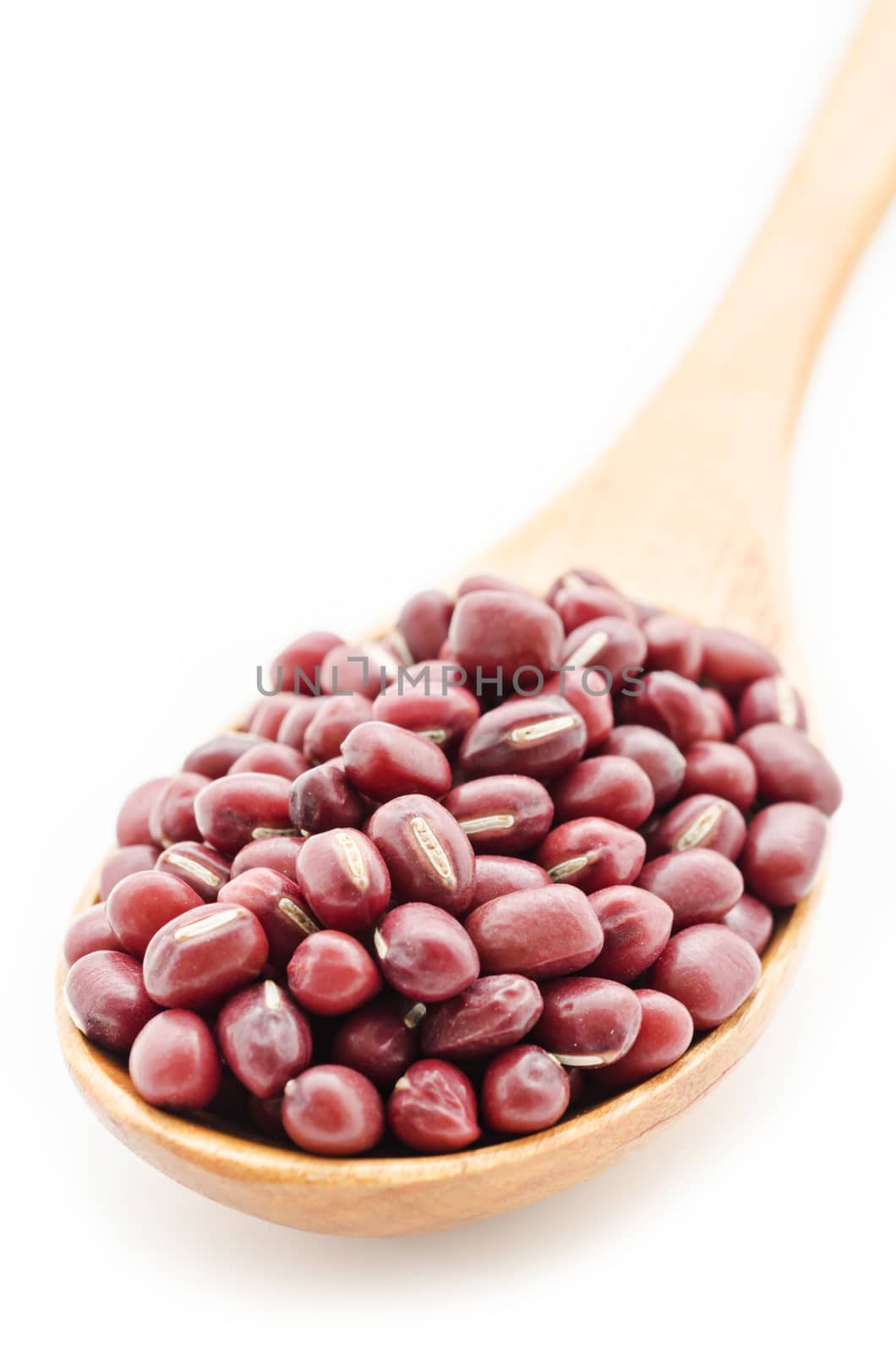 Raw azuki beans in wooden spoon on white background.