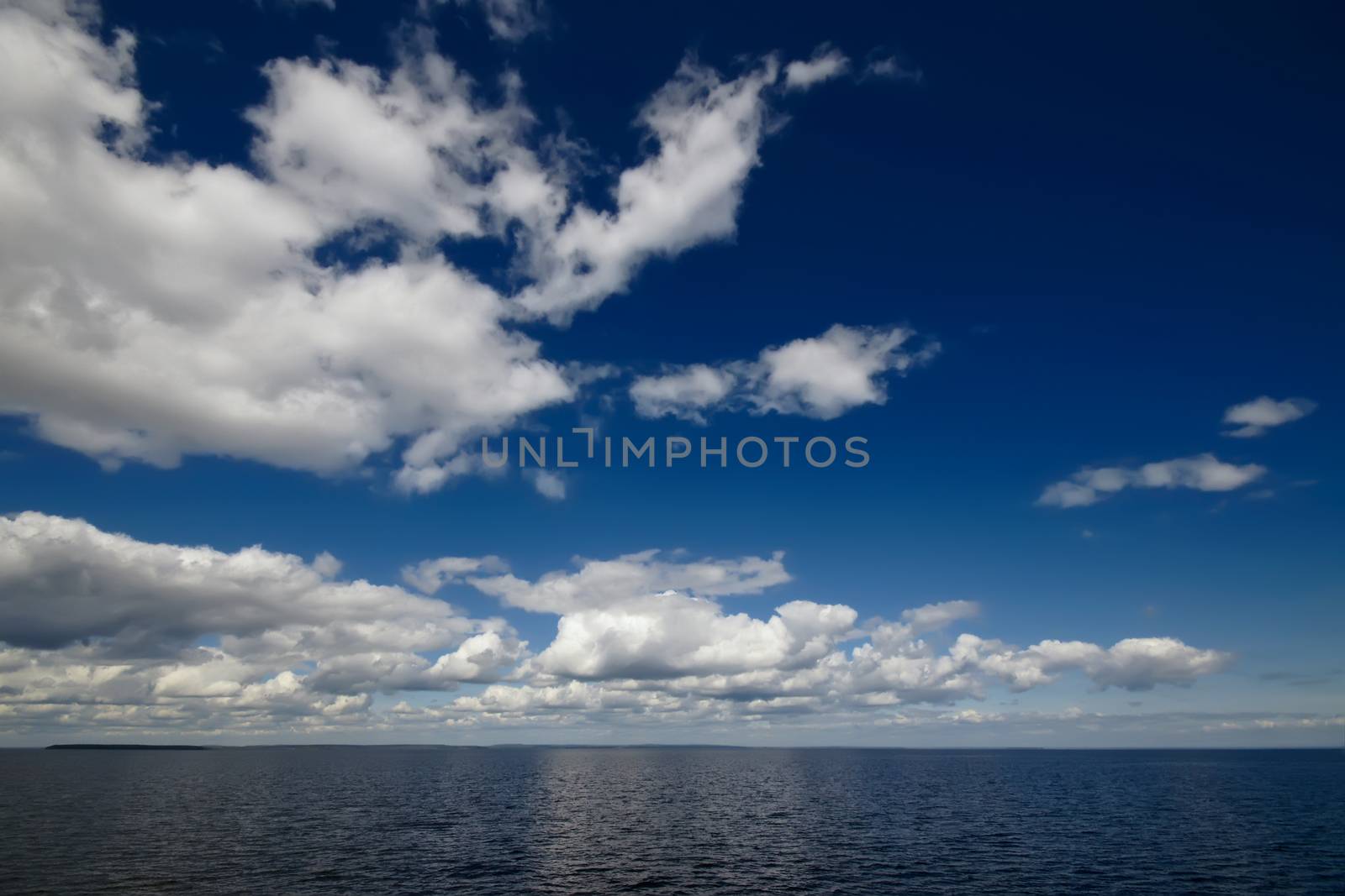 Blue sky with clouds over sea by mowgli