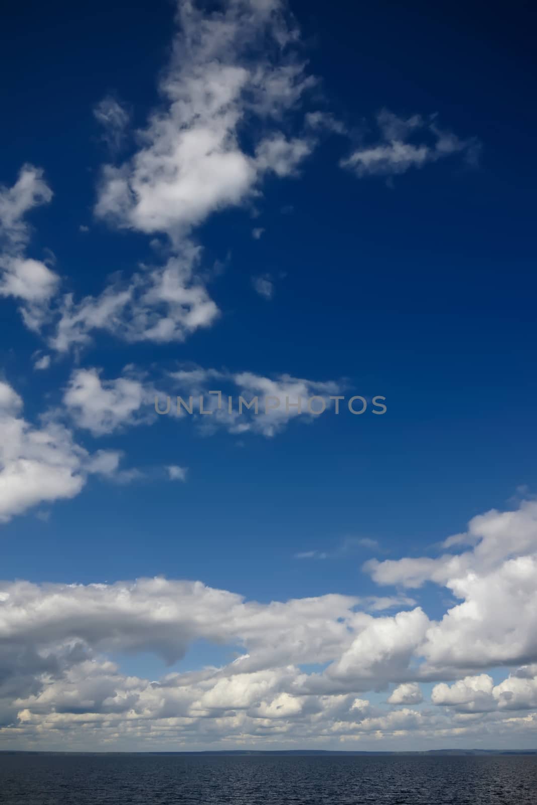 Blue sky with clouds over sea by mowgli