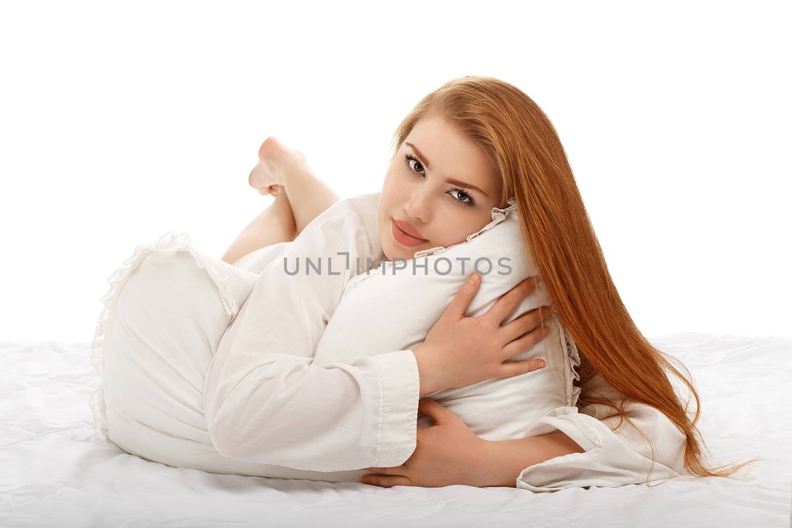 Portrait of a beautiful sexy girl lying in bed in a man's shirt isolated on white background