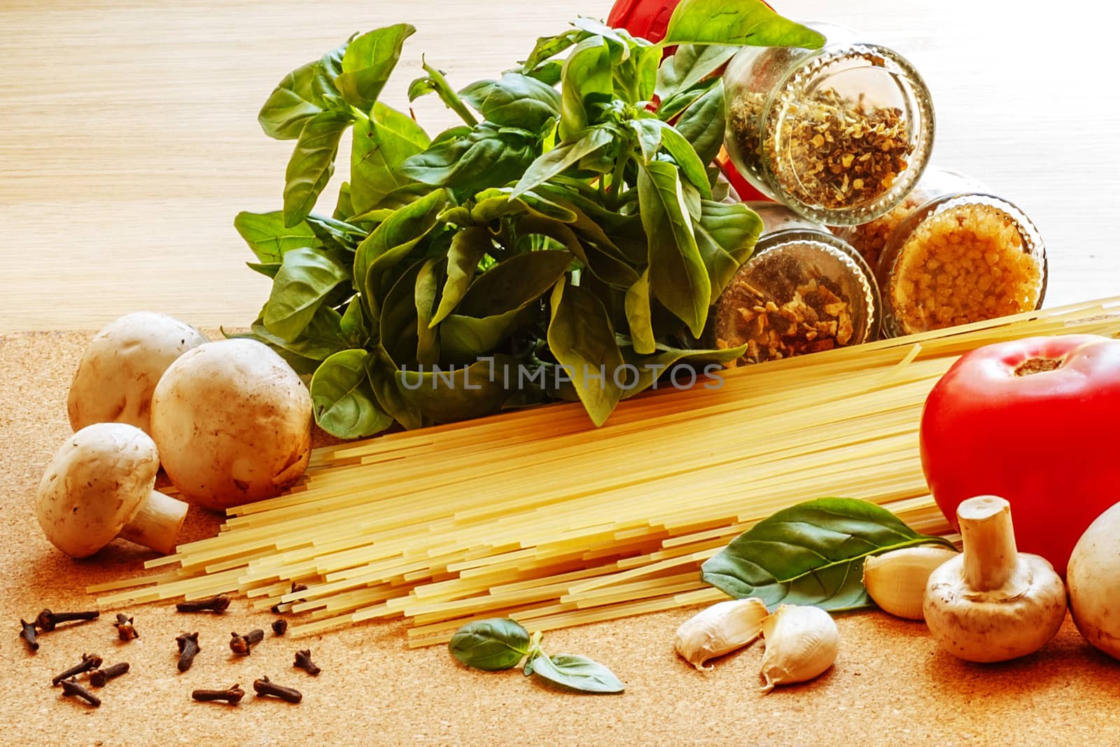 ingredients for cooking Italian pasta on a cork board