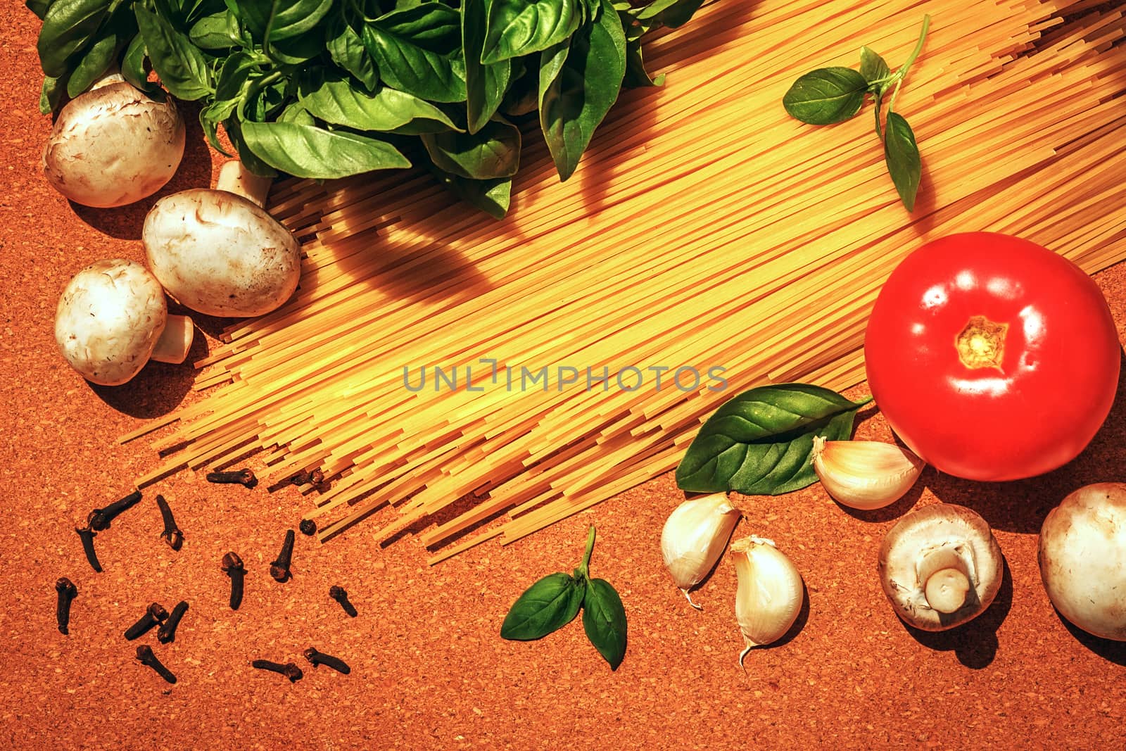 ingredients for cooking Italian pasta on a cork board