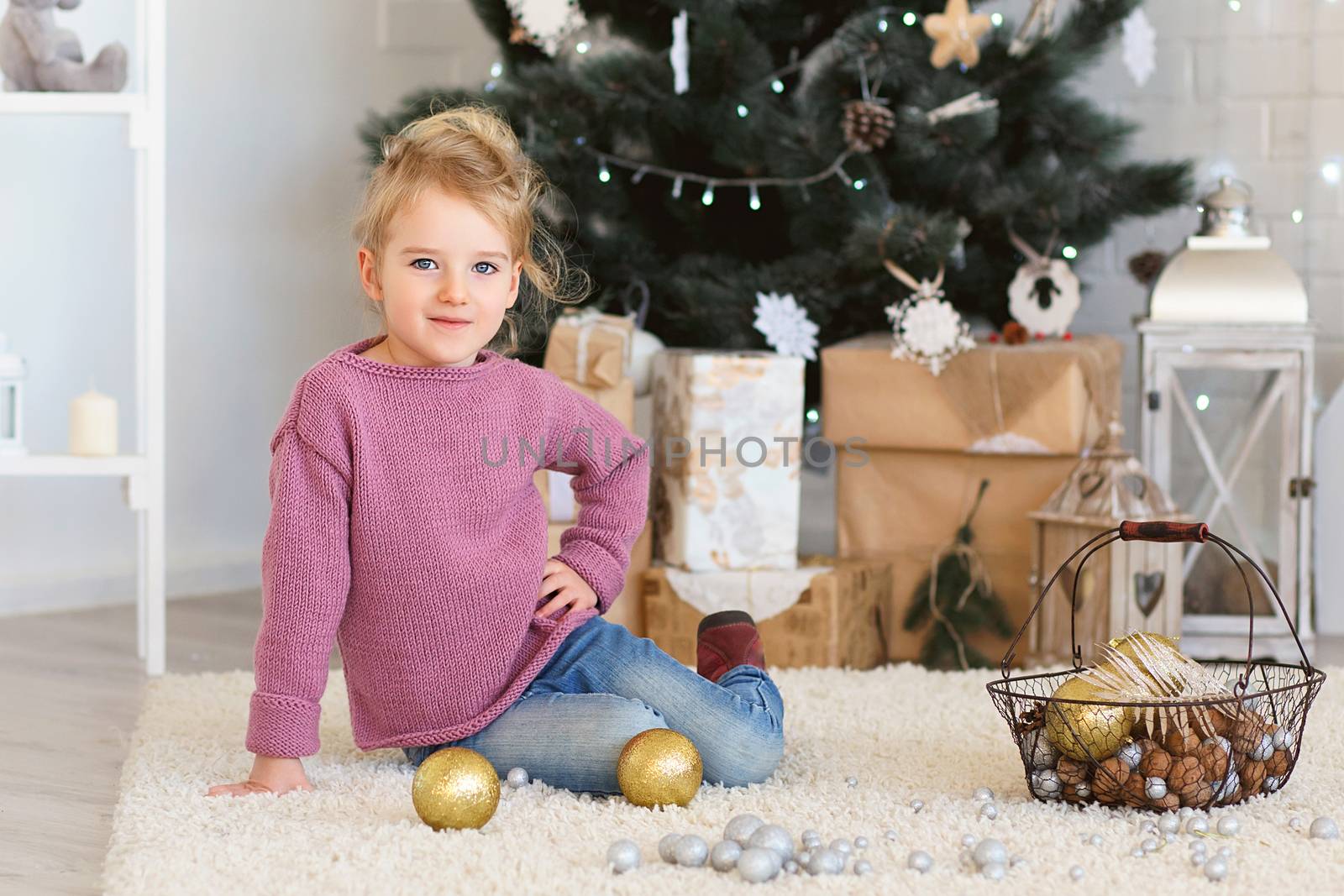 Little girl waiting for a miracle in Christmas decorations by natazhekova