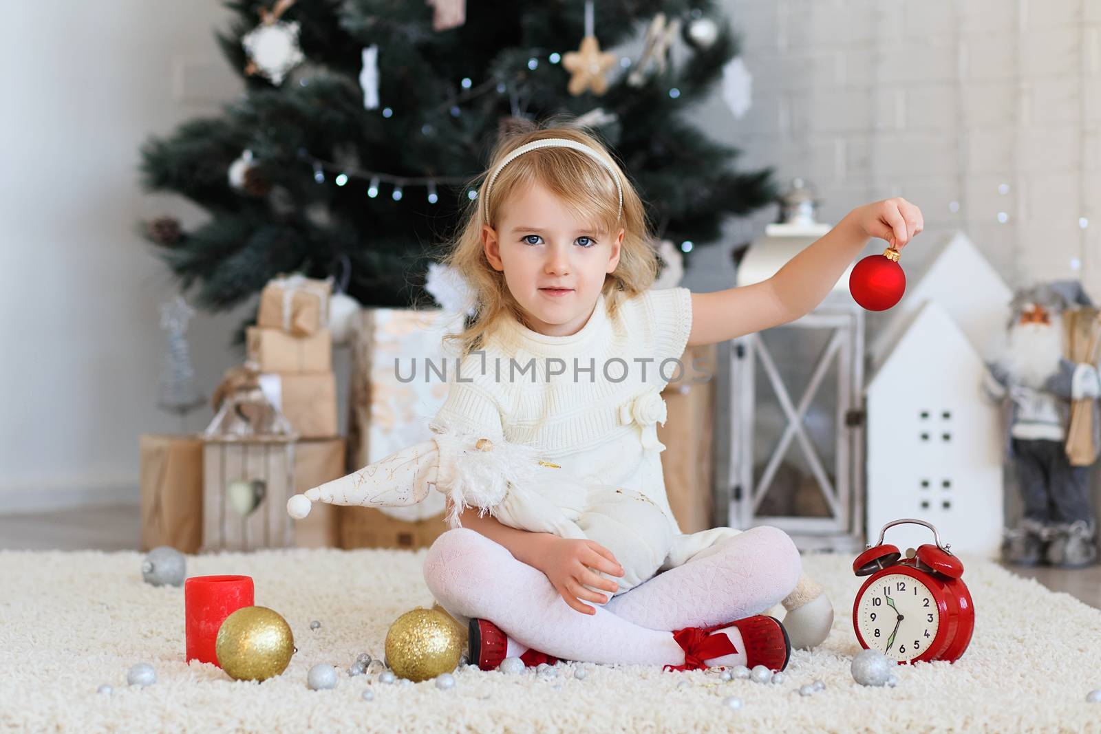 Little girl waiting for a miracle in Christmas decorations by natazhekova