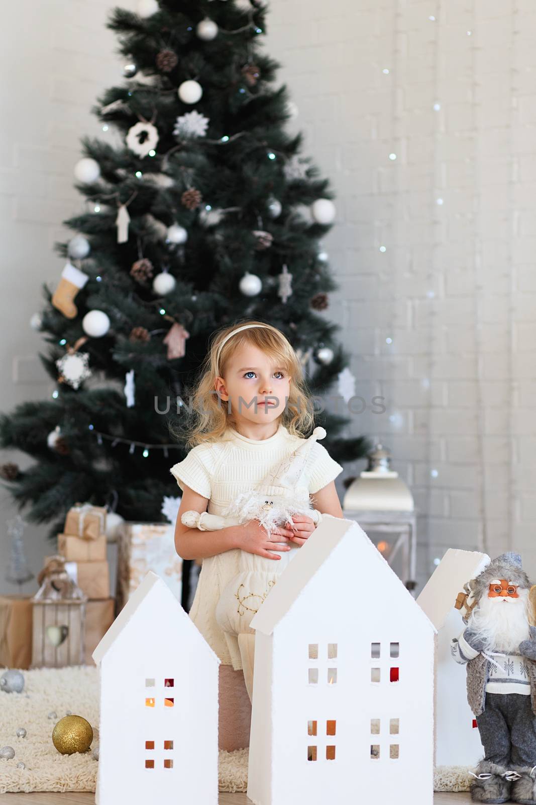 Beautiful Little girl waiting for a miracle in Christmas decorations