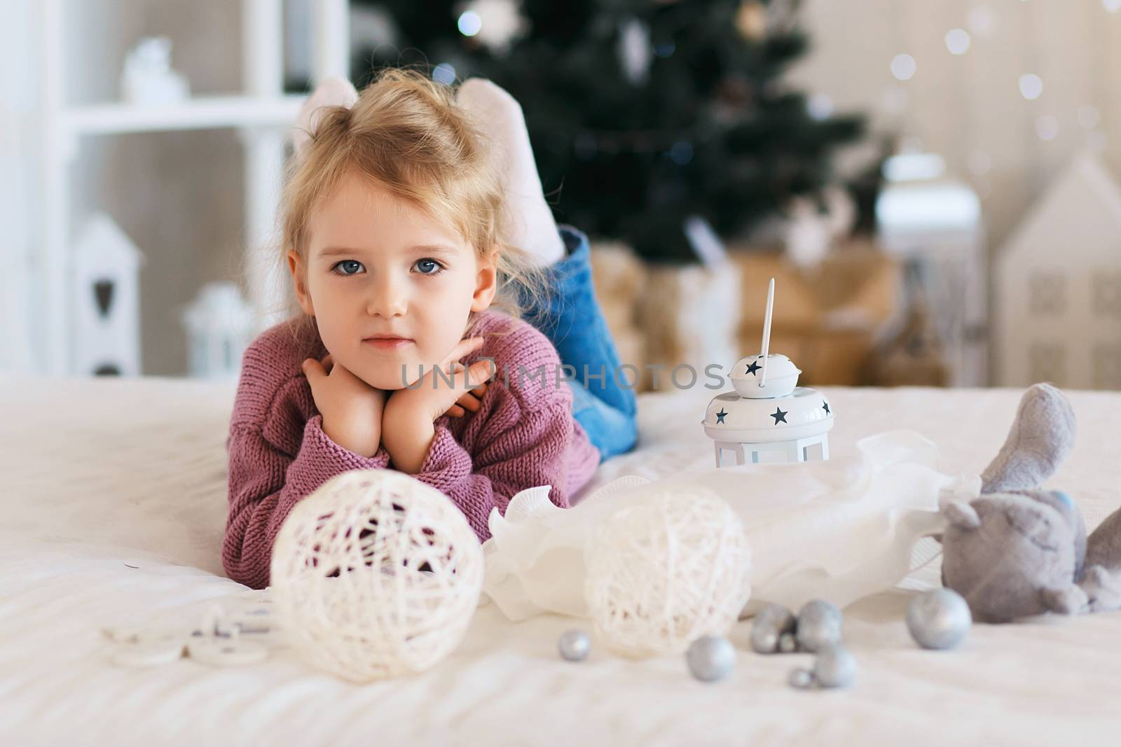 Little girl waiting for a miracle in Christmas decorations by natazhekova