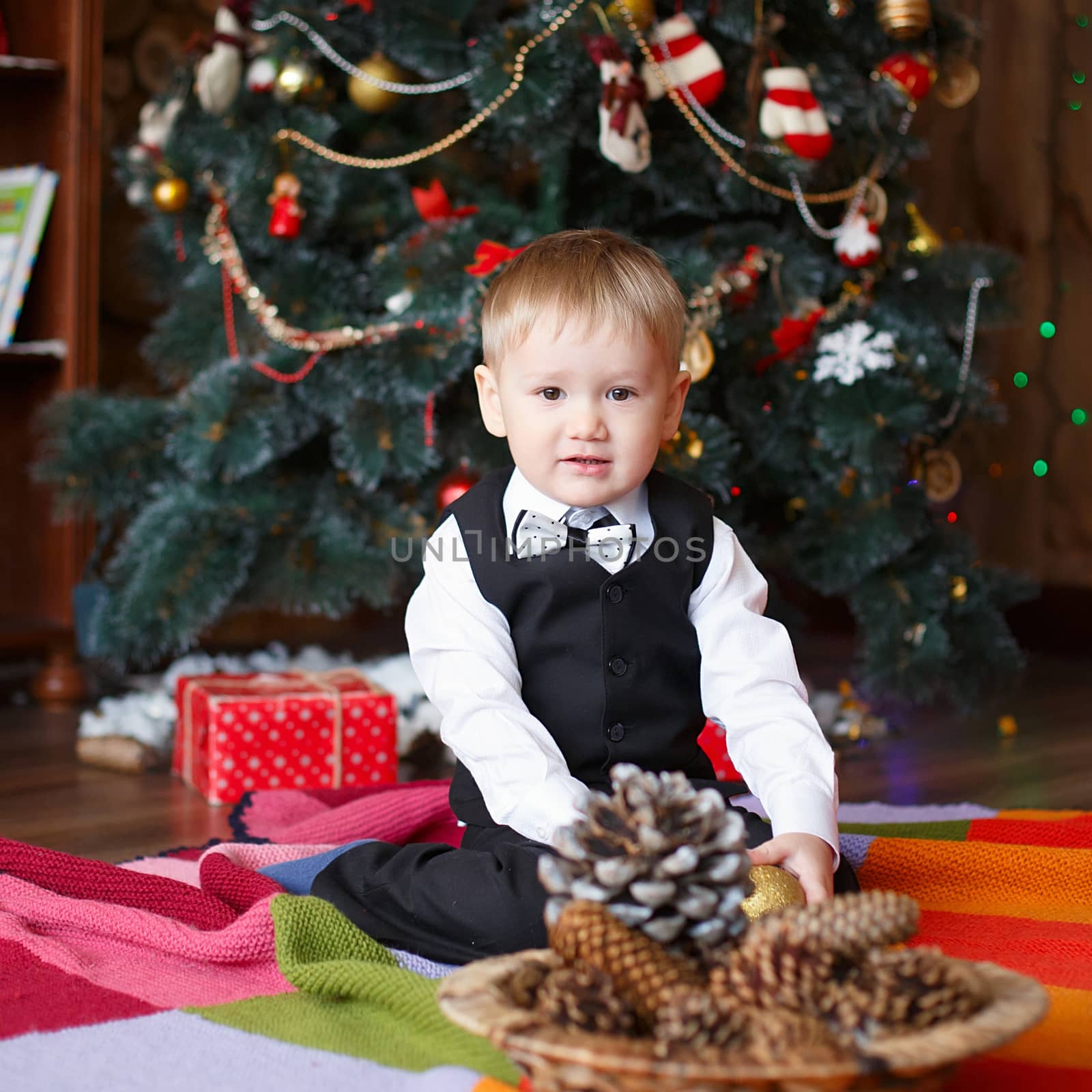 Little boy in Christmas decorations expect a miracle by natazhekova