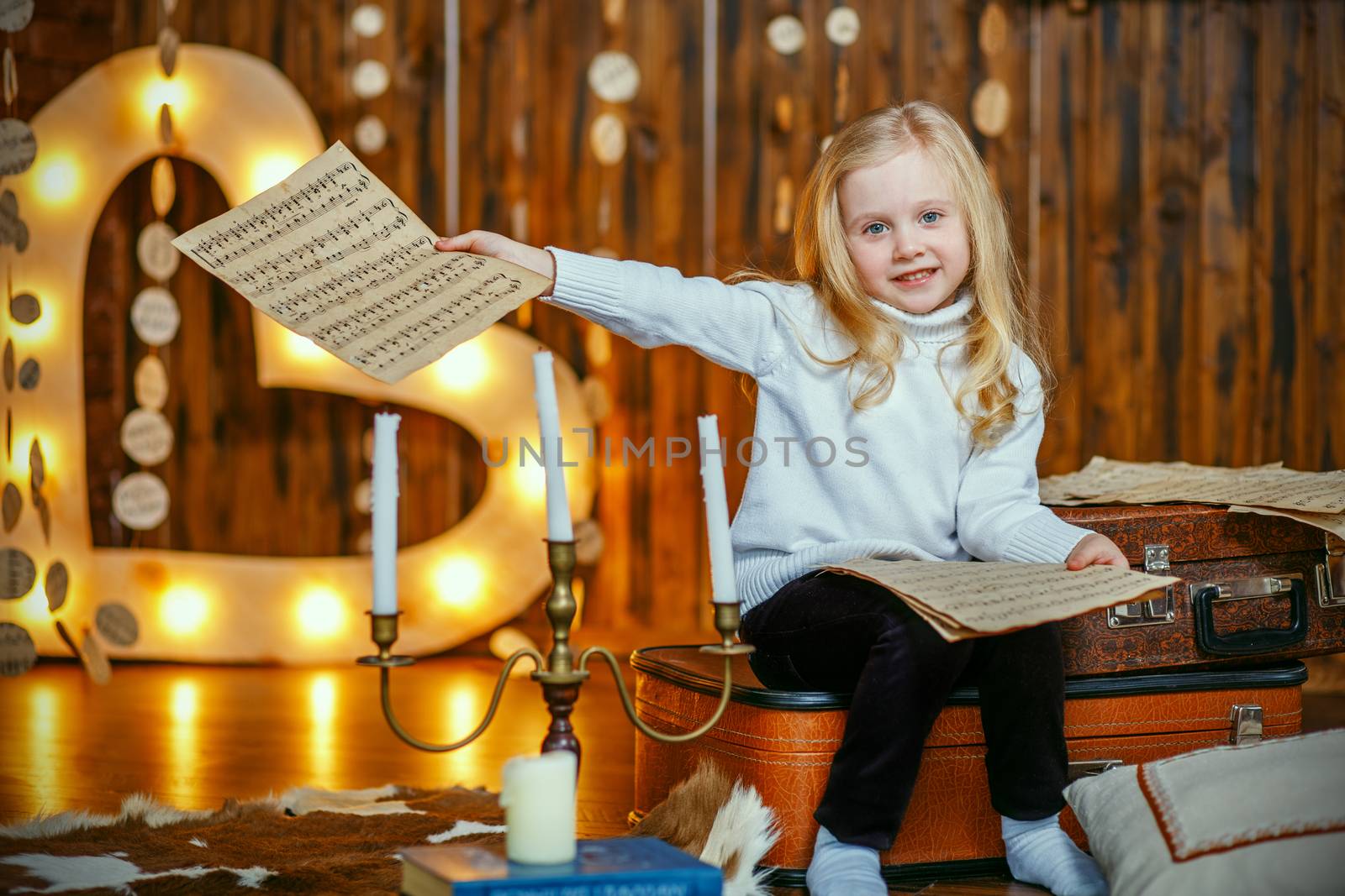 Blonde little girl holding a note in vintage interior